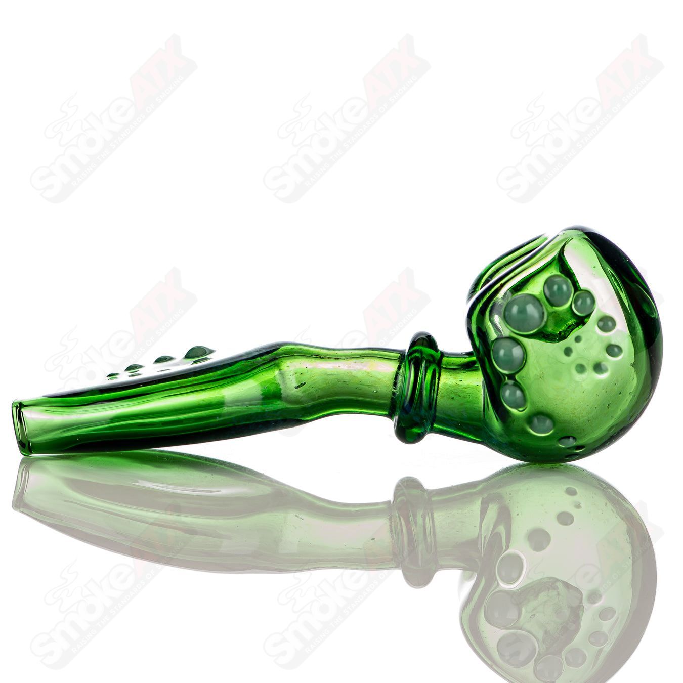 Large green layback spoon hand pipe by JMass, made of heady glass with a curved design and vibrant green color.