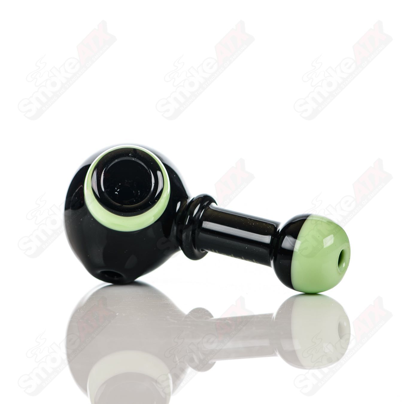 Illadelph black and milky green glass multi-hole spoon pipe with multiple air holes for smooth smoking experience.