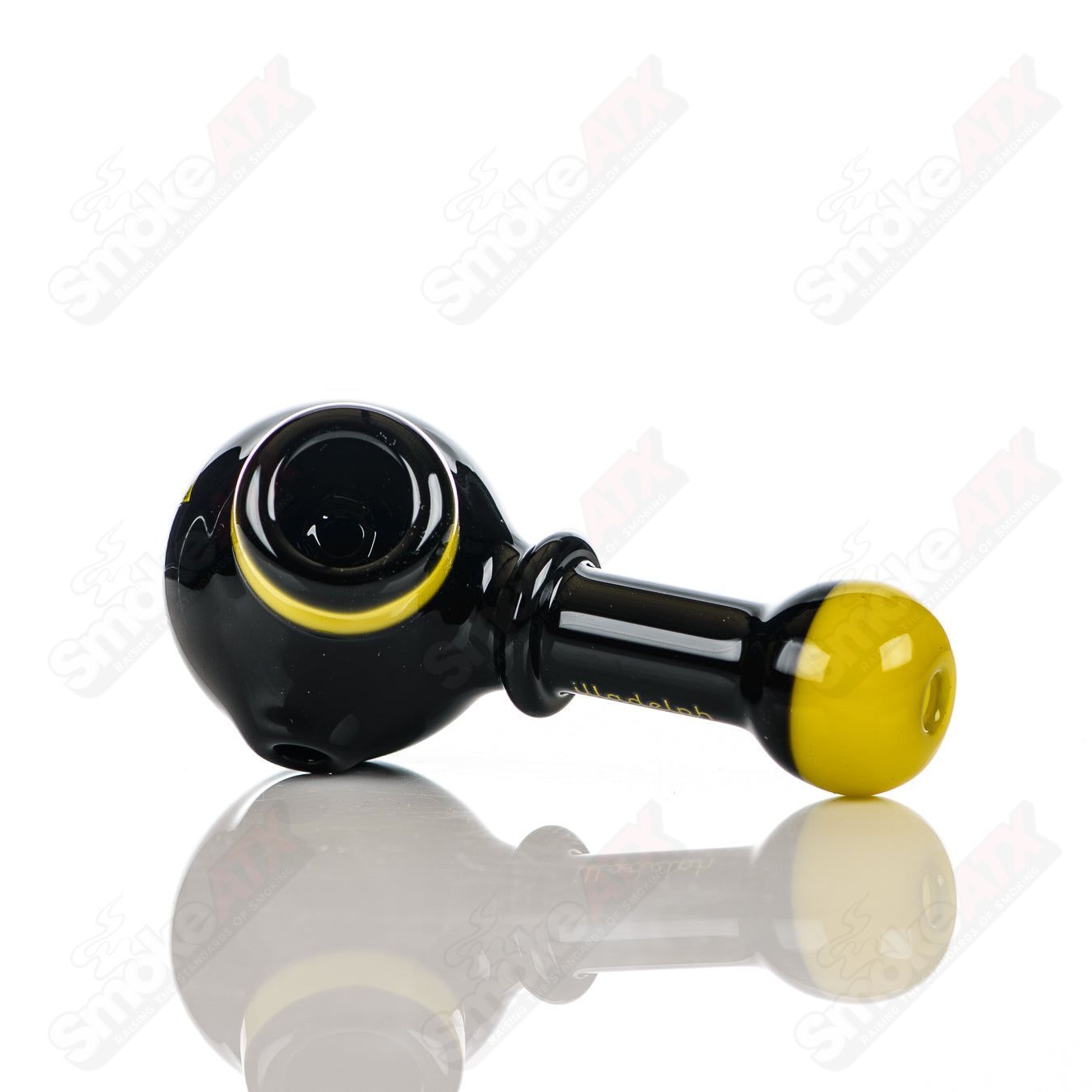Illadelph glass multi-hole spoon pipe in black and yellow with multiple holes for airflow, designed for smooth smoking experiences.