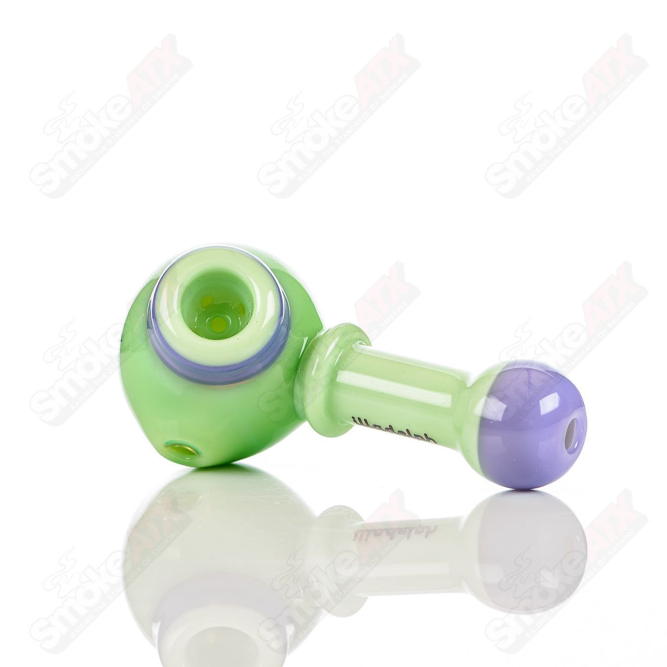 Illadelph glass multi-hole spoon pipe in milky green and purple with multiple holes for airflow, designed for smoking.