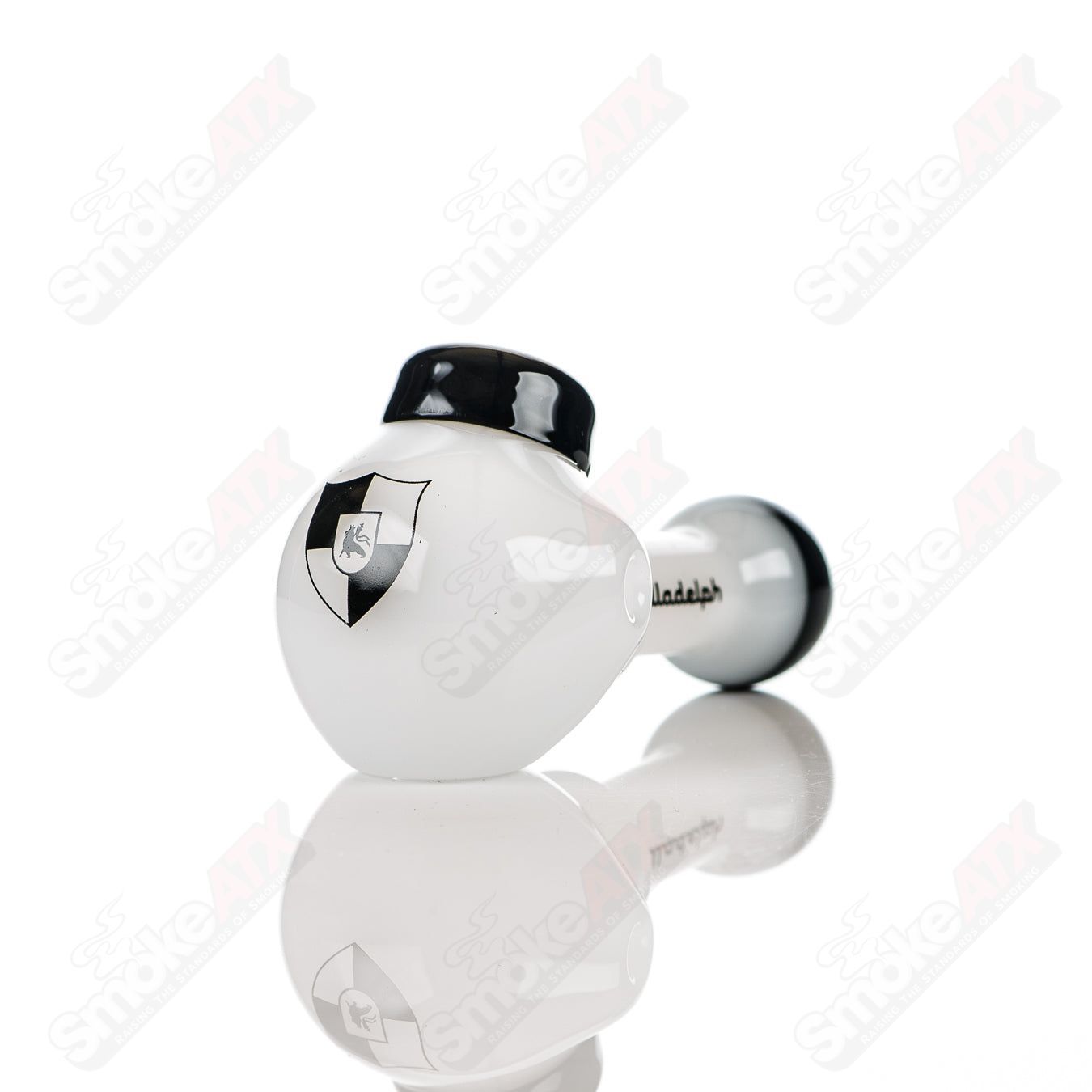 White and black glass multi-hole spoon pipe by Illadelph, featuring multiple holes and a smooth, rounded bowl design.