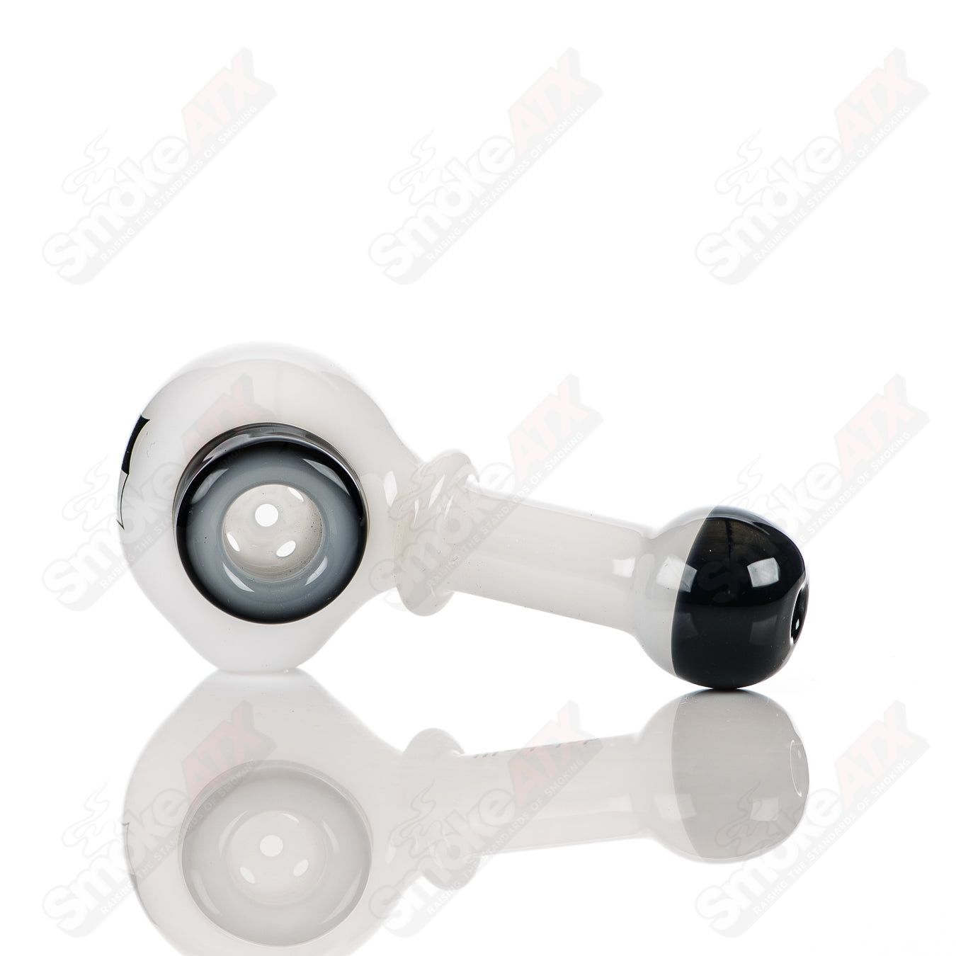 White and black Illadelph glass multi-hole spoon pipe with multiple holes and a smooth, rounded bowl for smoking.