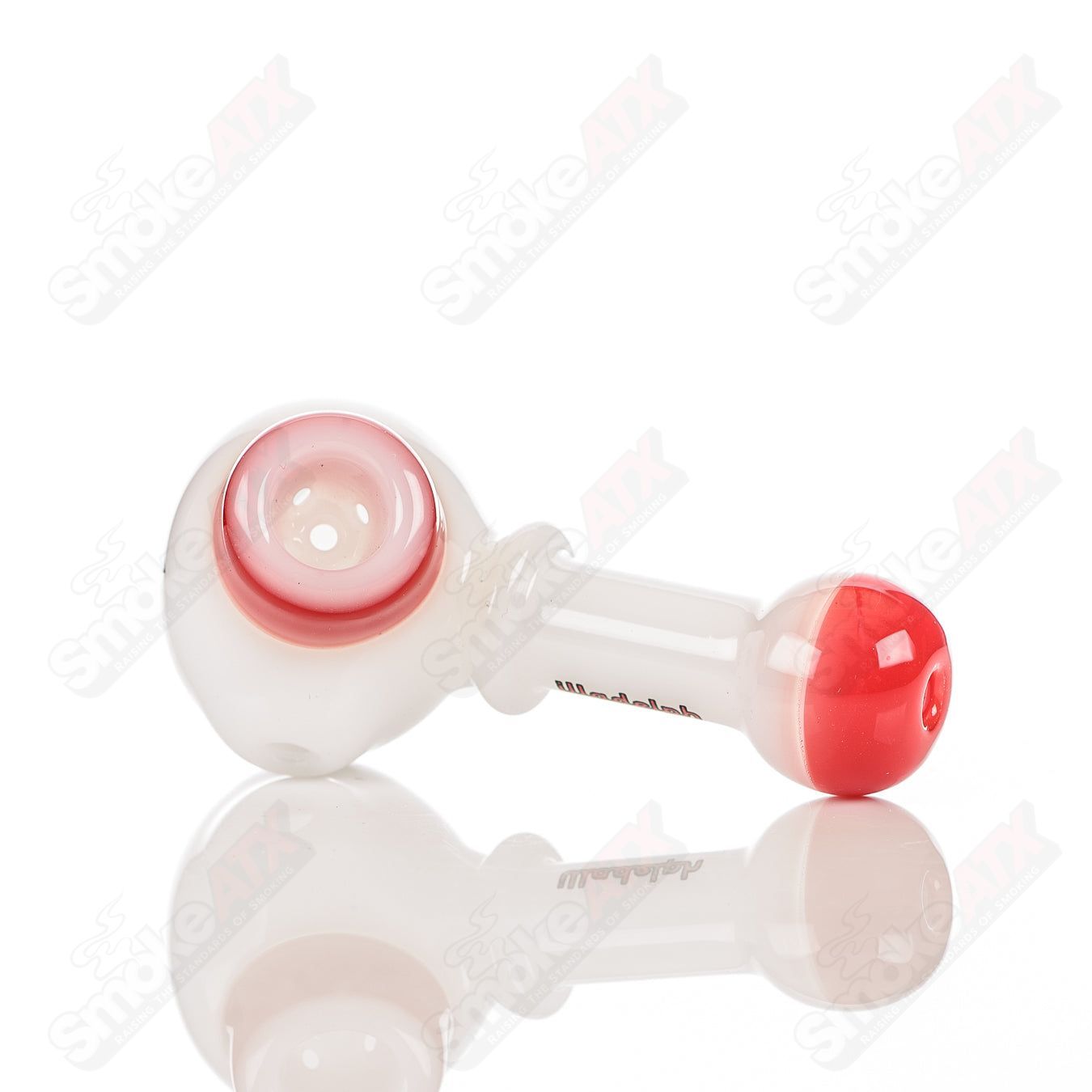 White and red Illadelph glass multi-hole spoon pipe with multiple holes and a smooth, rounded bowl for smoking.