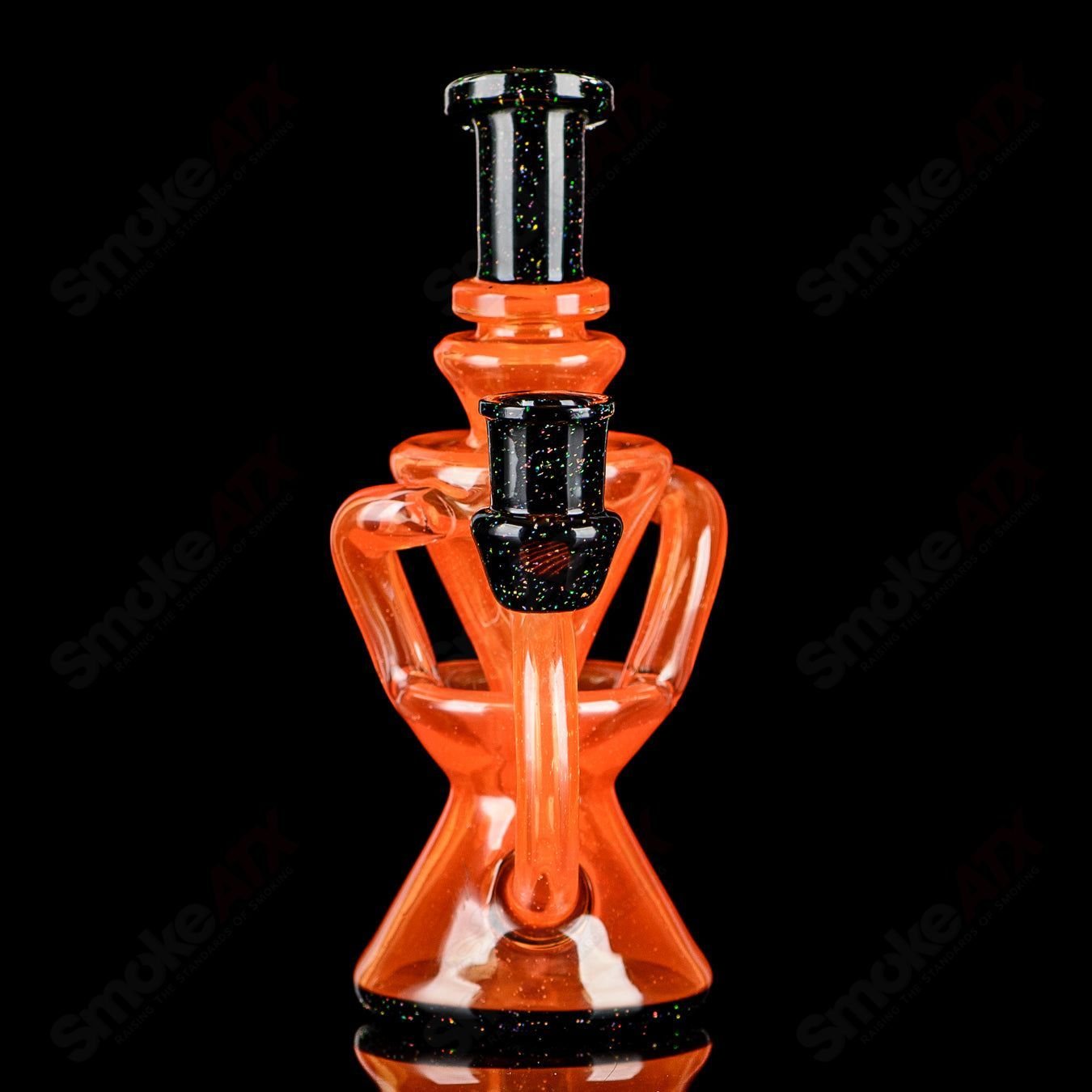 Orange and black crushed opal mini recycler rig by Captn Chronic, glass concentrate rig with vibrant color details.
