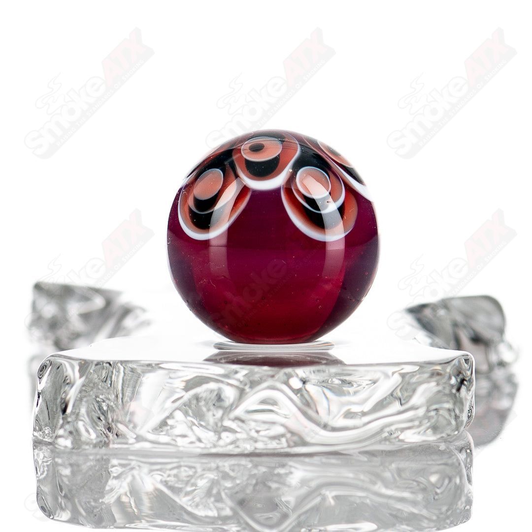 Red, black, and white dot stacked glass marbles from Indo Glass, featuring colorful, glossy glass spheres arranged in a decorative pattern.