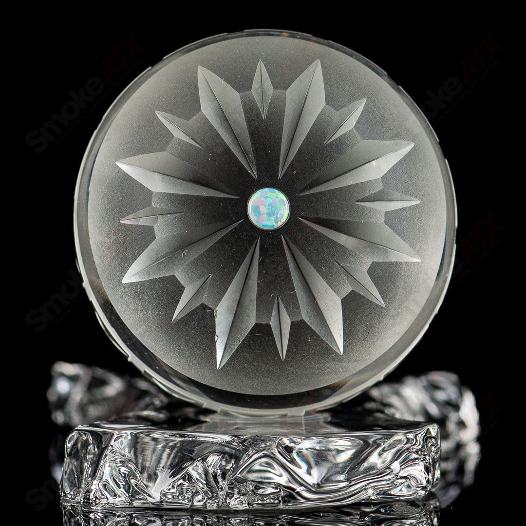 Large faceted snowflake marble by Fatal Facets, showcasing intricate glasswork with a snowflake design and vibrant colors.
