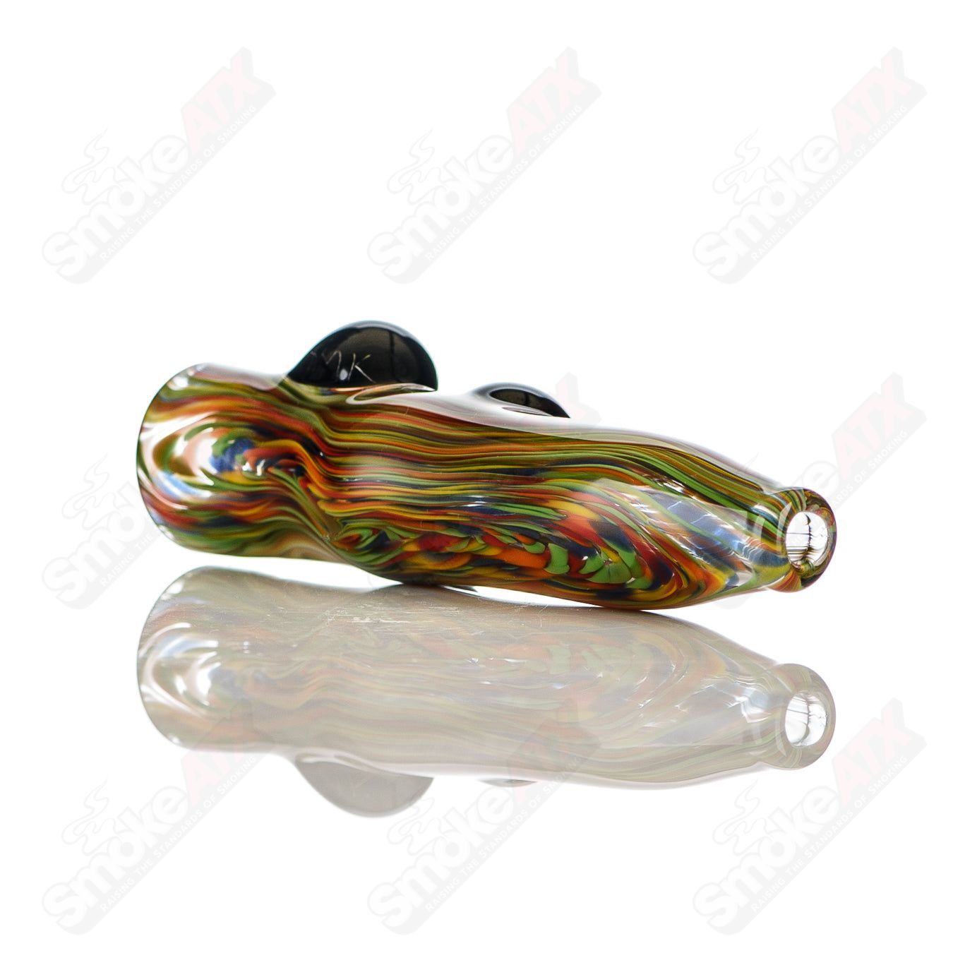 Rainbow-colored glass chillum by JMK Glass featuring black dot accents and signature design, displayed on a plain background.