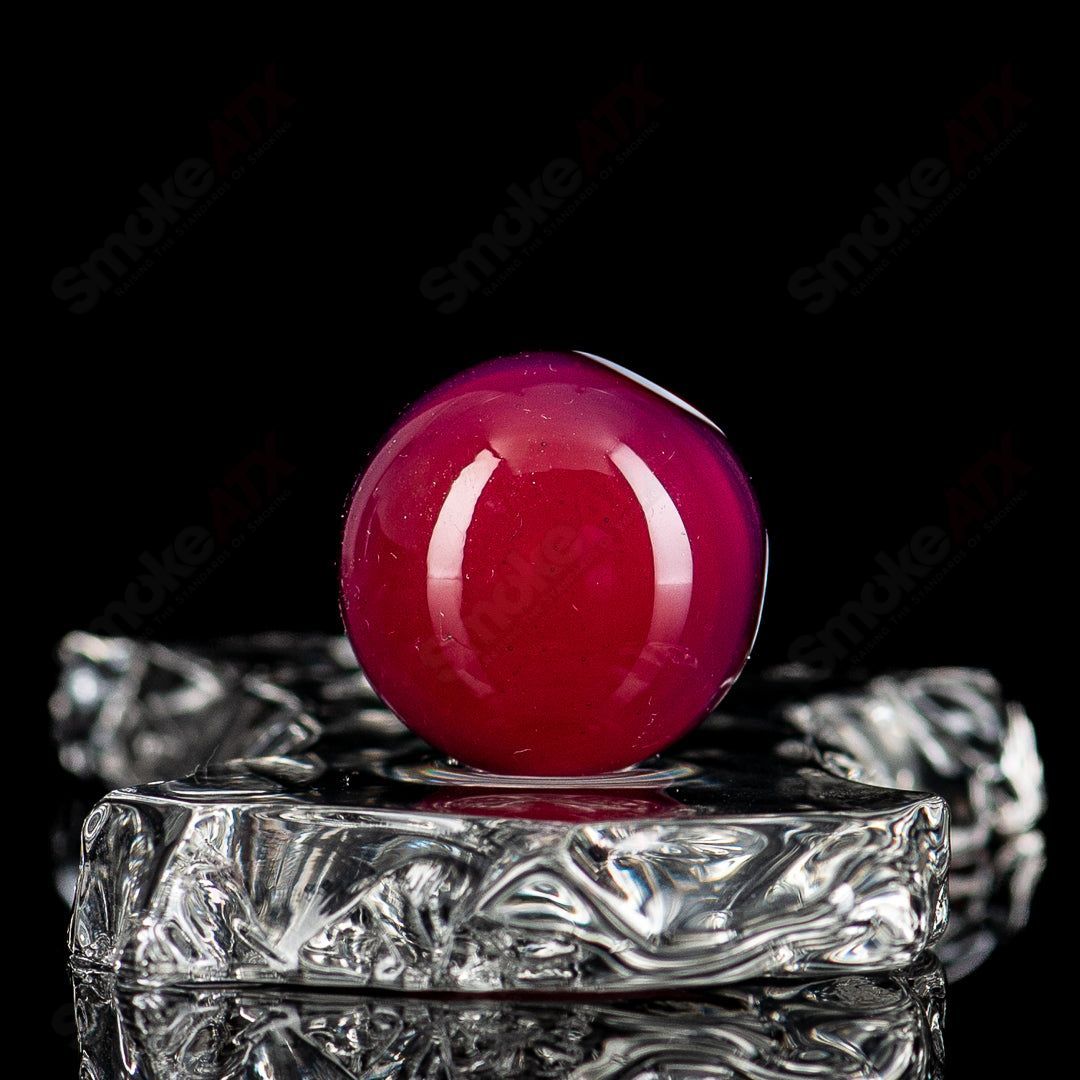 Red, black, and white dot stacked glass marbles from Indo Glass arranged in a close-up shot.