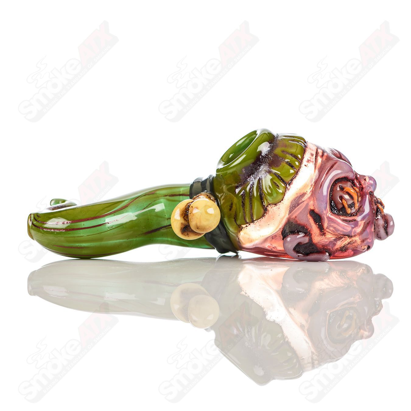 Hand pipe featuring a shrunken head design from Ghost Glass, made of clear glass with detailed sculpted features.
