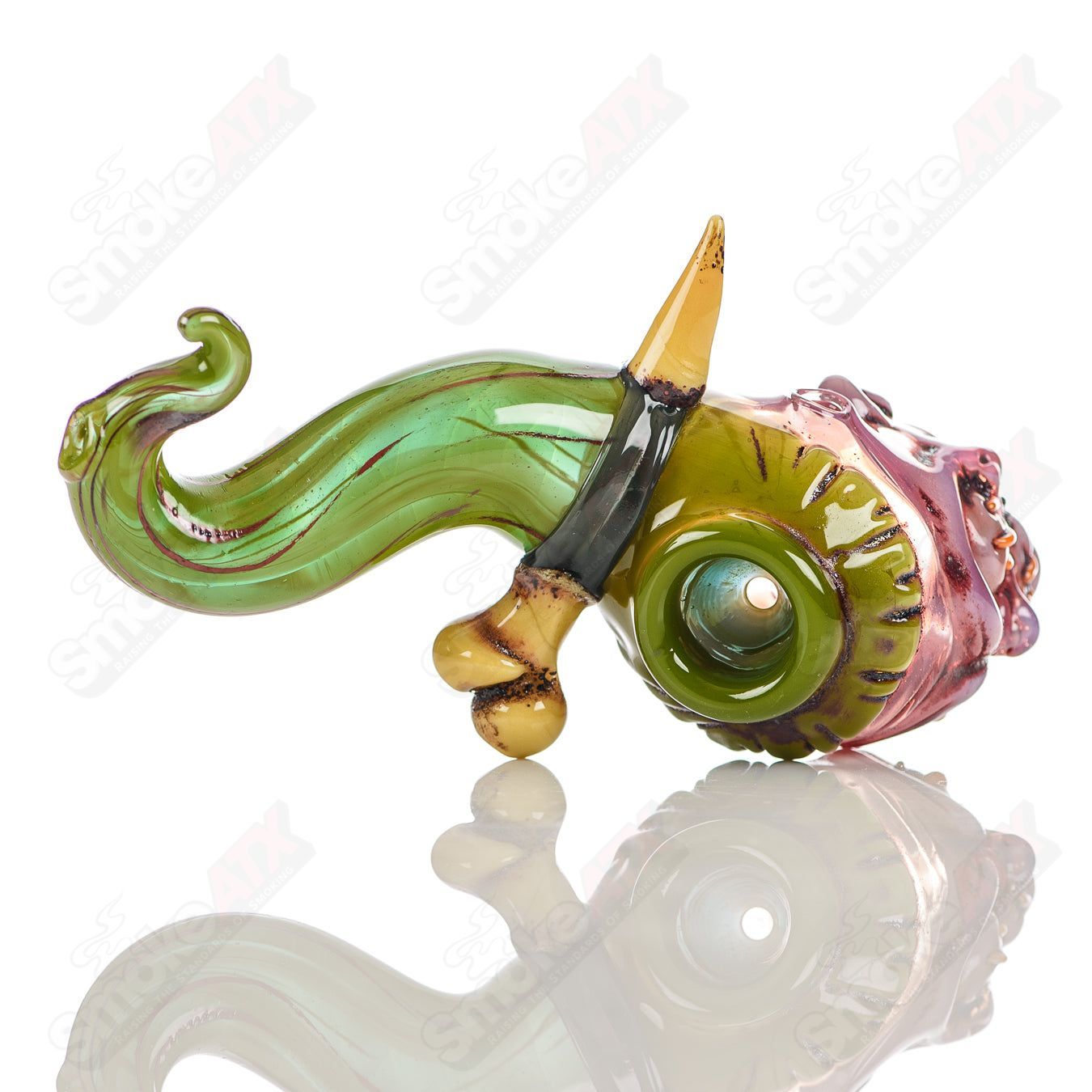 Hand pipe by Ghost Glass featuring a shrunken head design in clear glass with intricate detailing.
