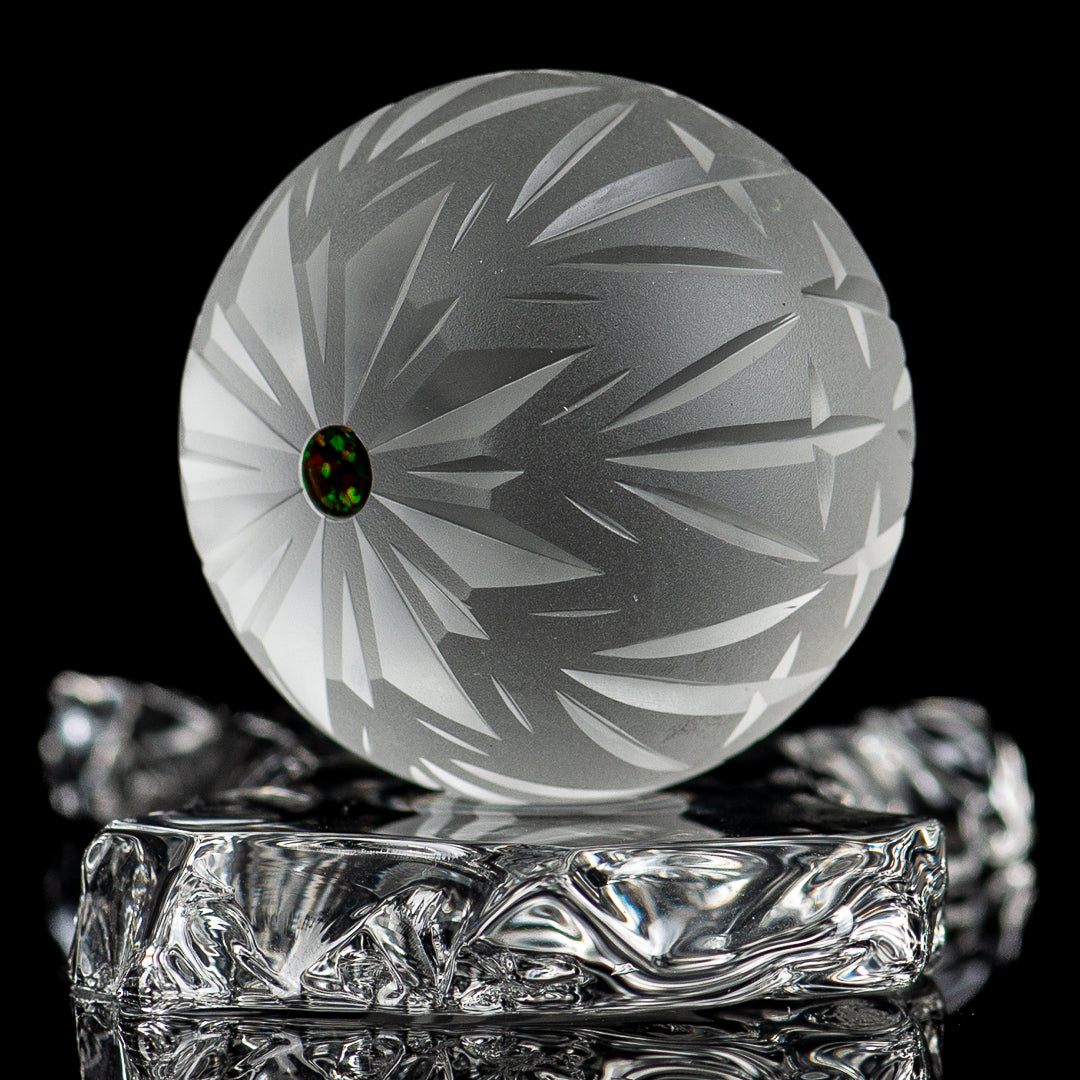 Faceted snowflake marble by Fatal Facets, glass marble with intricate snowflake design, shiny and smooth surface.