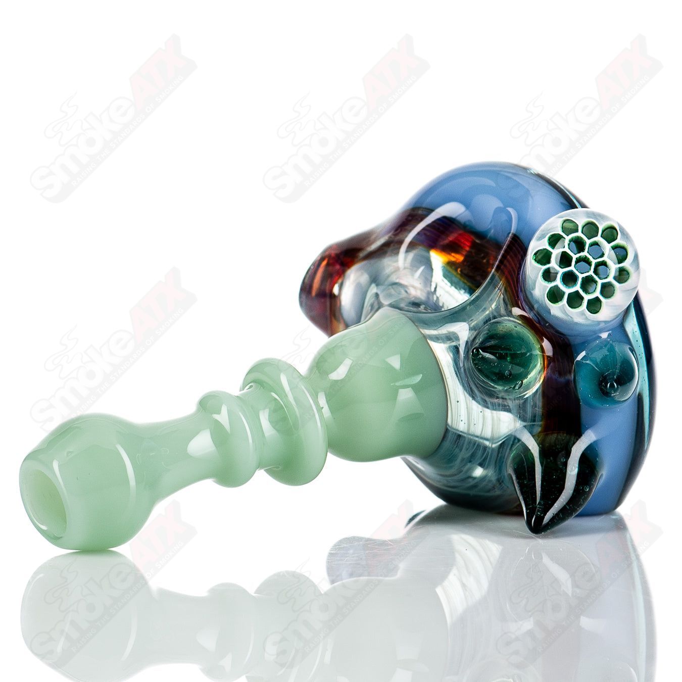 JMass Spiked Spoon Hand Pipe with honeycomb design in vibrant glass, featuring spiked accents and intricate pattern details.