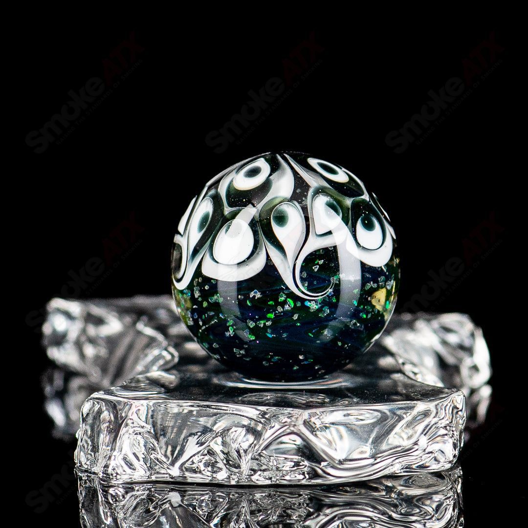 Black Magic UV Pinwheel Top marble by Indo Glass, colorful glass marble with a pinwheel design, suitable for glass collections.