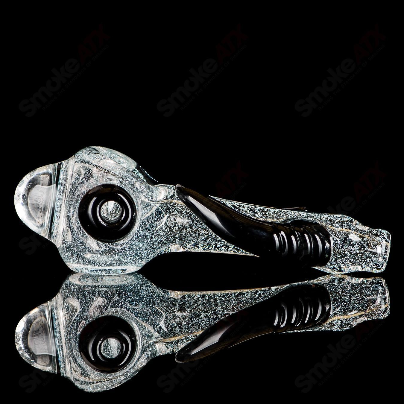 Transparent dichro spoon pipe with black horn accents, signed by JMK Glass, designed for heady glass and hand pipe enthusiasts.
