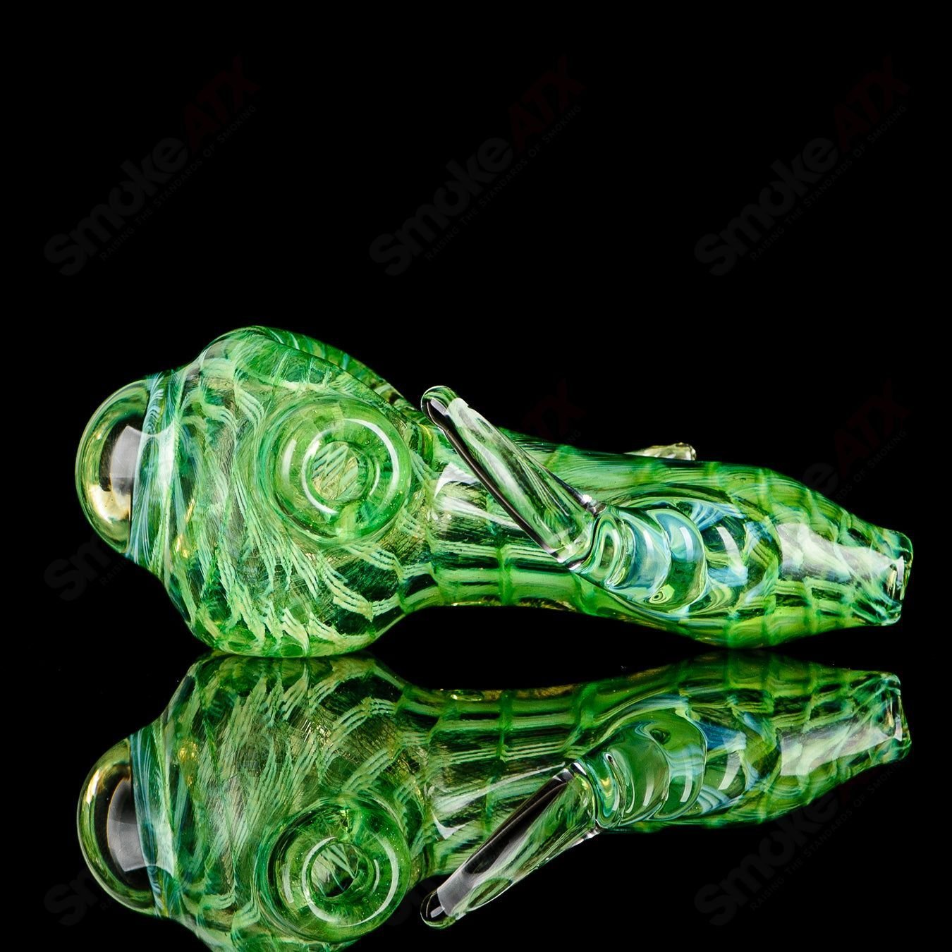 Transparent green I/O coil spoon pipe with clear horn accents, signed by JMK Glass, in the heady glass hand pipe collection.
