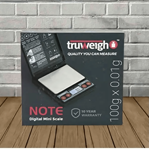 Truweigh Truweight Note digital scale showing a 100g weight, with a clear digital display and compact design.