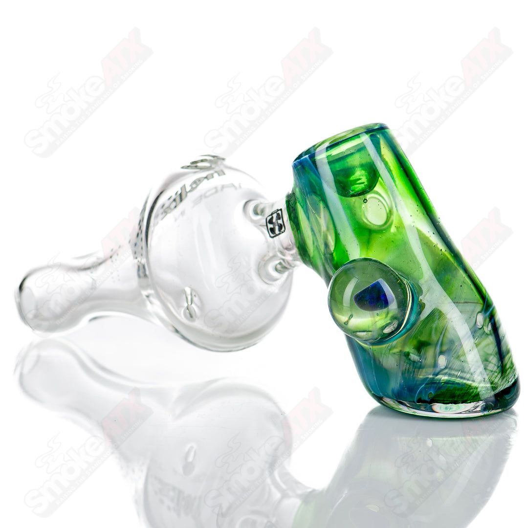 American Helix White Label Hammer glass pipe with blue-green box fan helix design, showcasing intricate glasswork and vibrant colors.