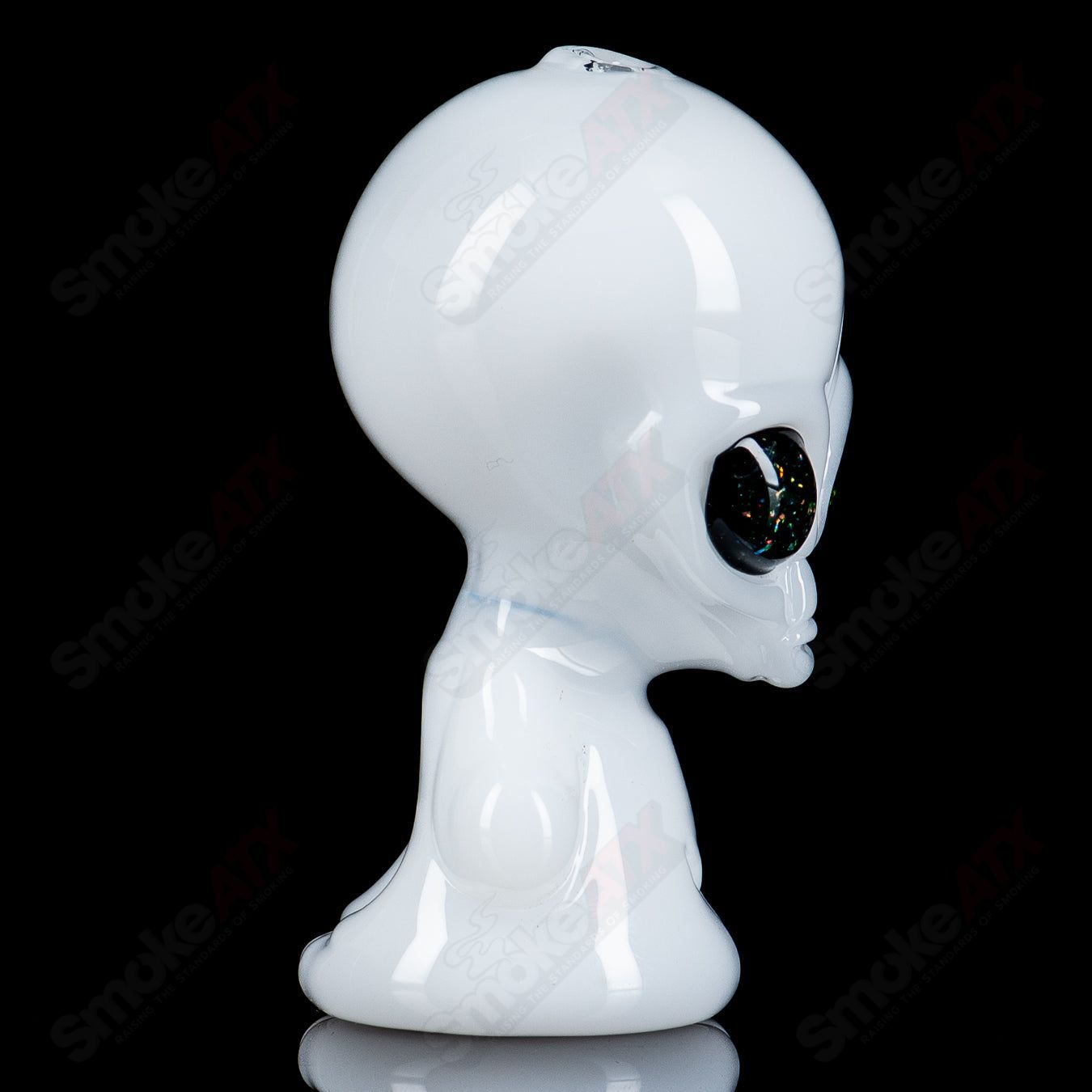 White alien hand pipe with UV crushed opal eyes, created by Ghost Glass, made of heady glass for smoking enthusiasts.