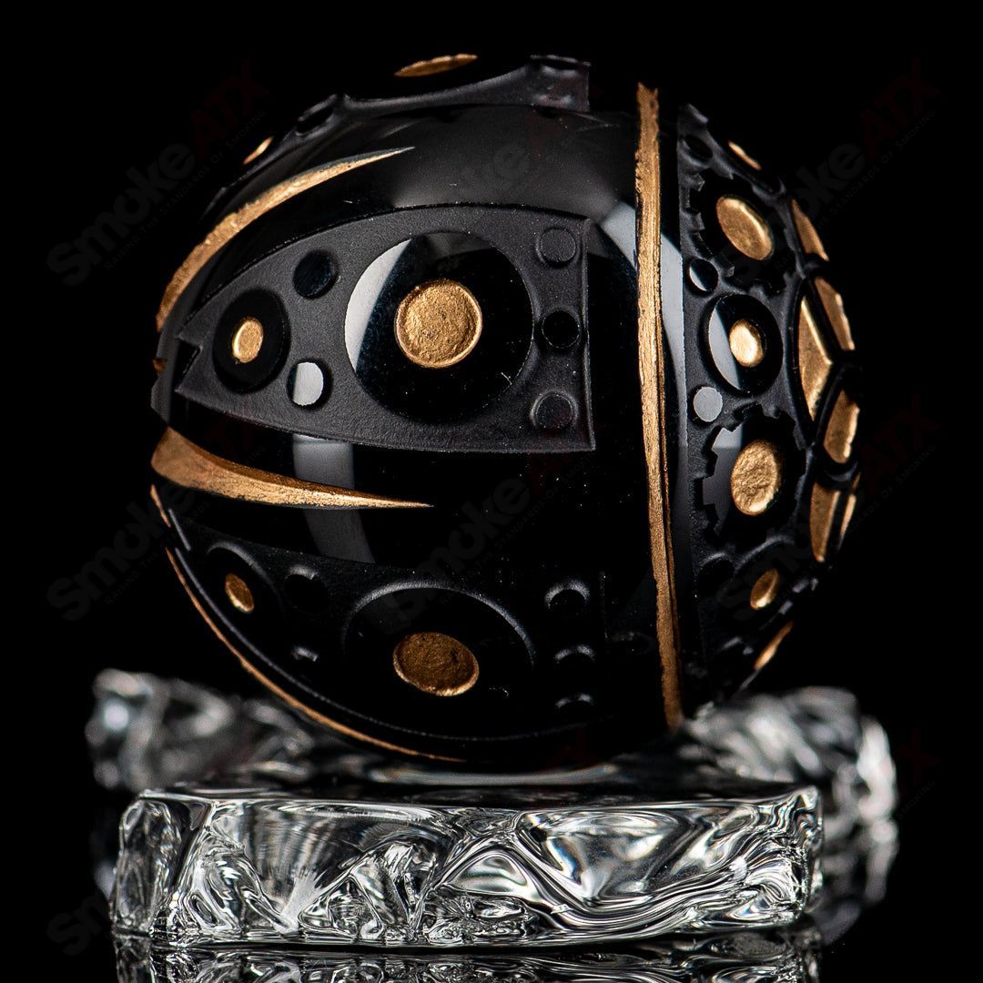 Black marble heady glass marbles from Fatal Facets with intricate Battuto design, showcasing smooth, polished surfaces.