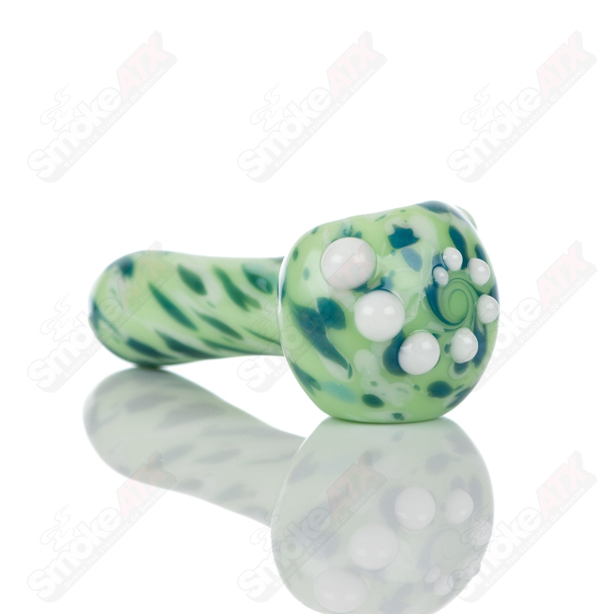 Colorful Kiwi splatter glass spoon pipe by Adventures In Glass Blowing, featuring vibrant green and purple design and smooth glass finish.