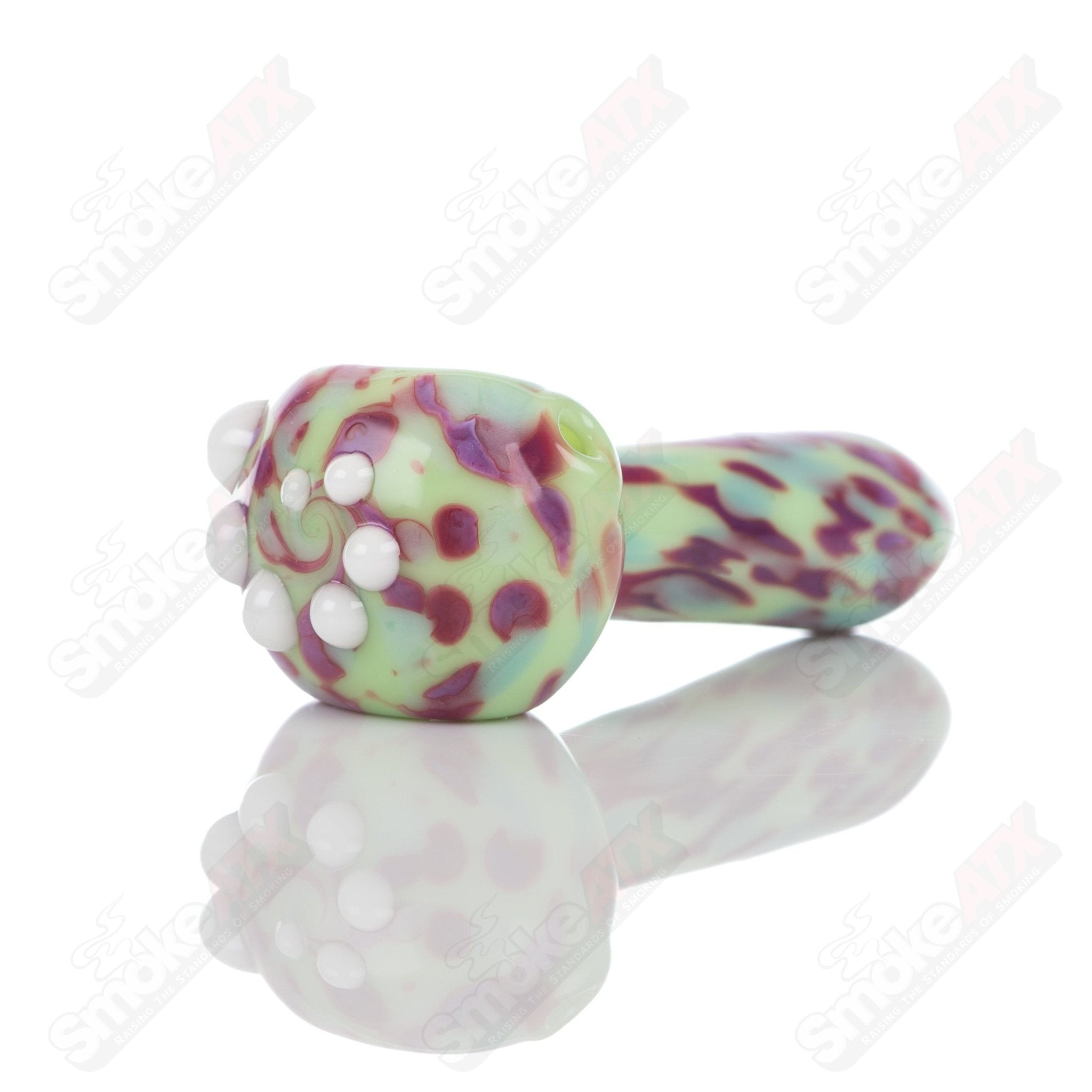 Colorful glass spoon pipe with kiwi splatter design by Adventures In Glass Blowing, showcasing intricate glass blowing craftsmanship.