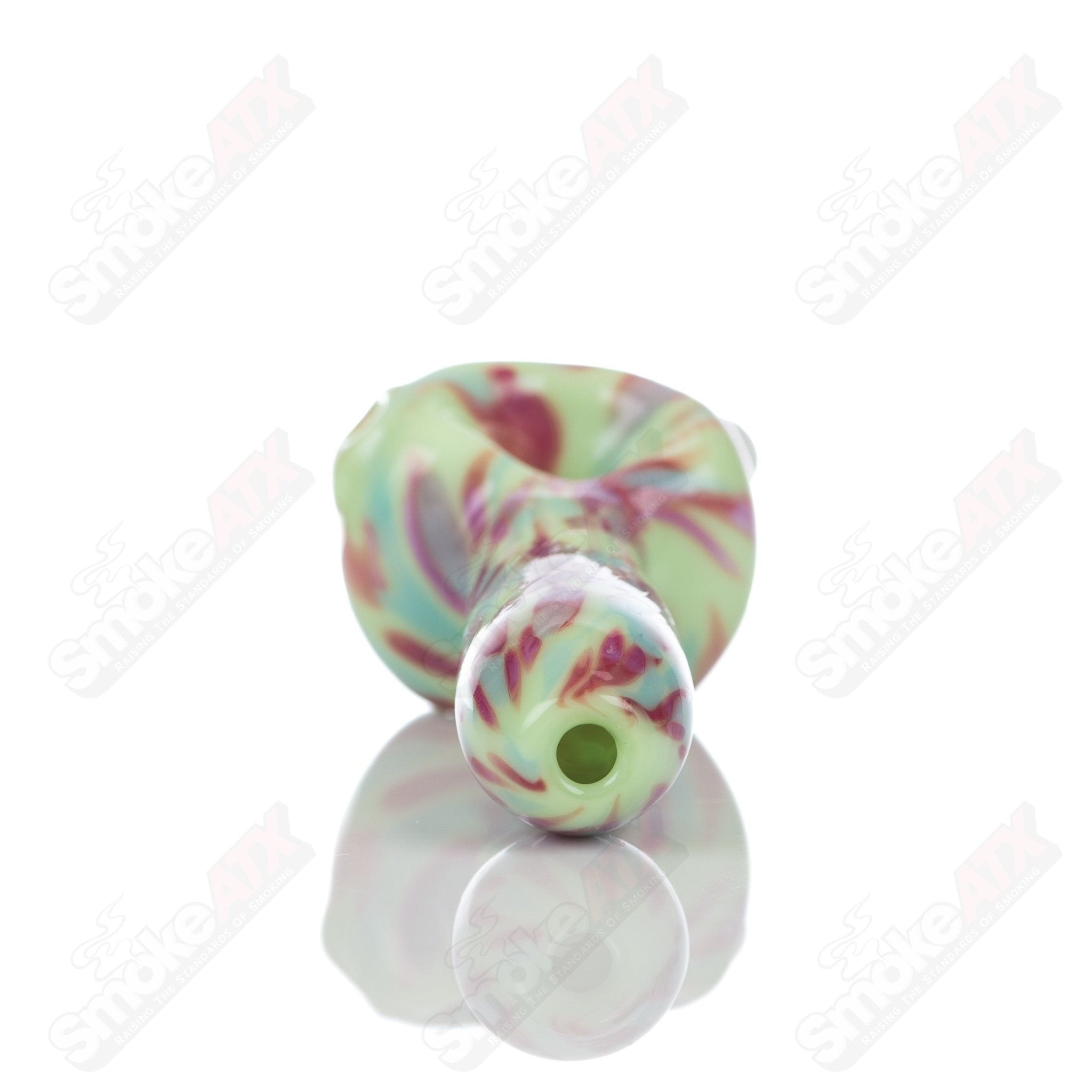 Colorful glass spoon pipe with kiwi splatter design by Adventures In Glass Blowing, showcasing a vibrant, hand-blown glass pipe.