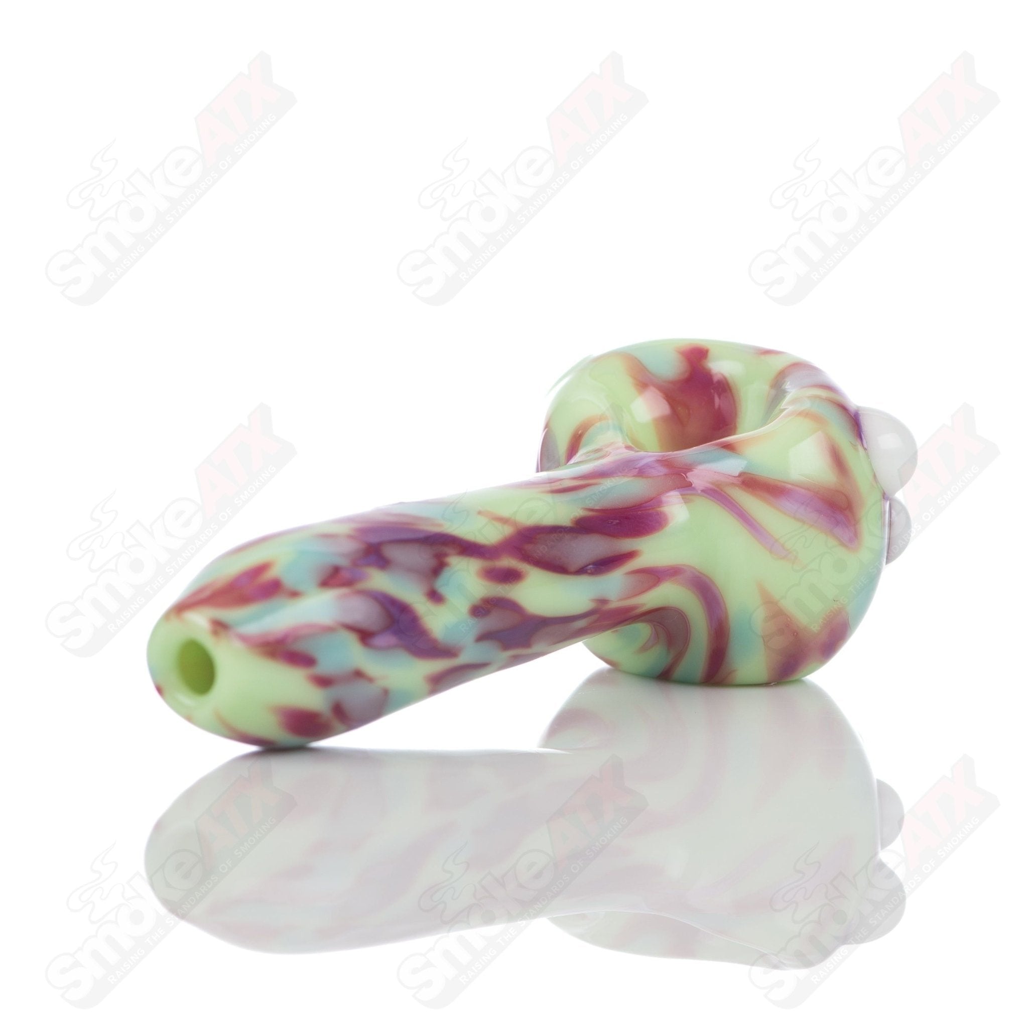 Colorful glass spoon pipe with kiwi splatter design by Adventures In Glass Blowing, featuring a smooth bowl and artistic glass craftsmanship.