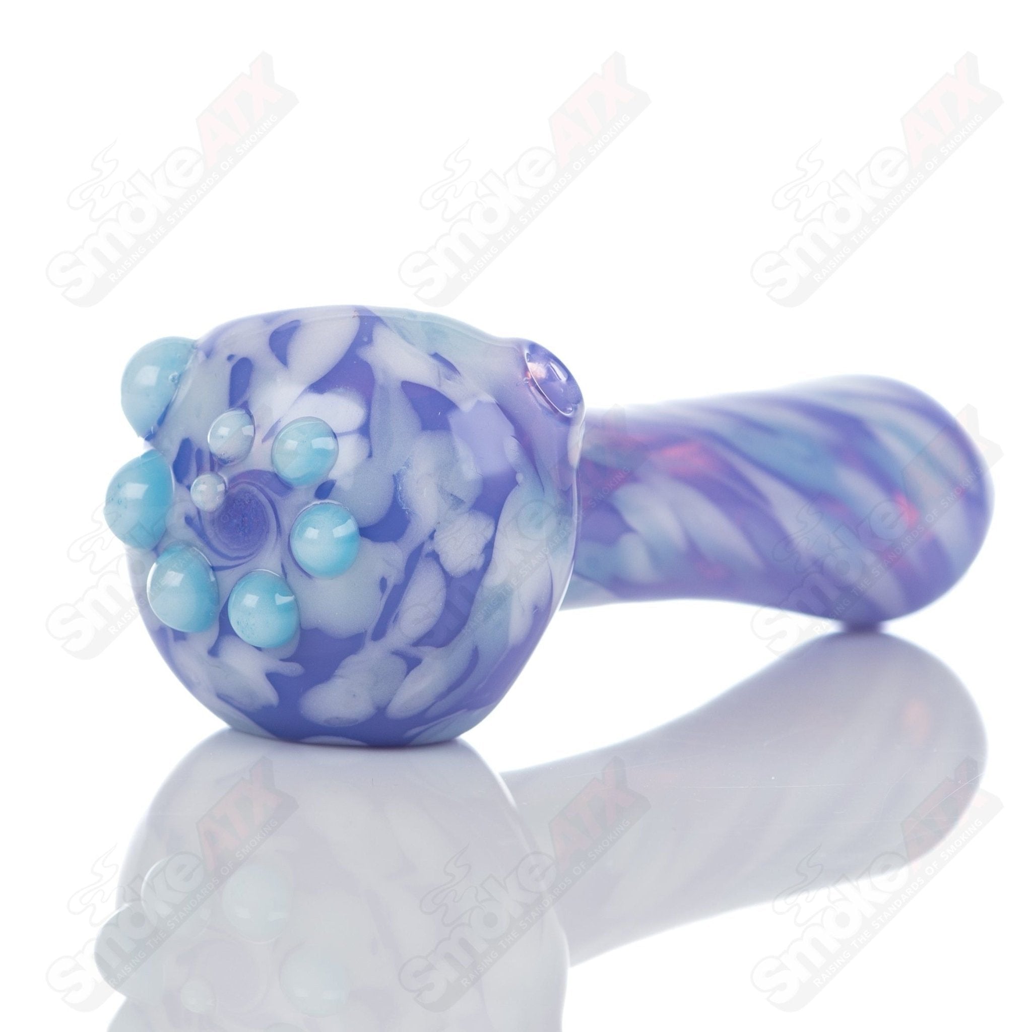 Purple splatter glass spoon pipe by Adventures In Glass Blowing, showcasing a vibrant, artistic smoking pipe with colorful design.