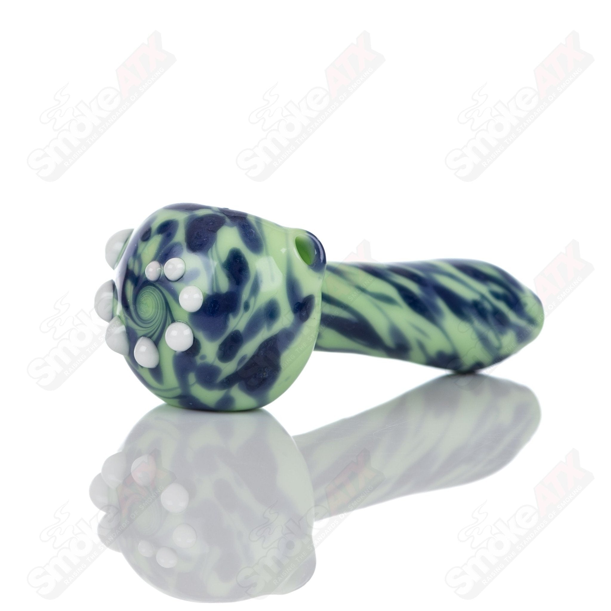 Colorful glass spoon pipe with kiwi splatter design by Adventures In Glass Blowing, showcasing intricate glass blowing craftsmanship.