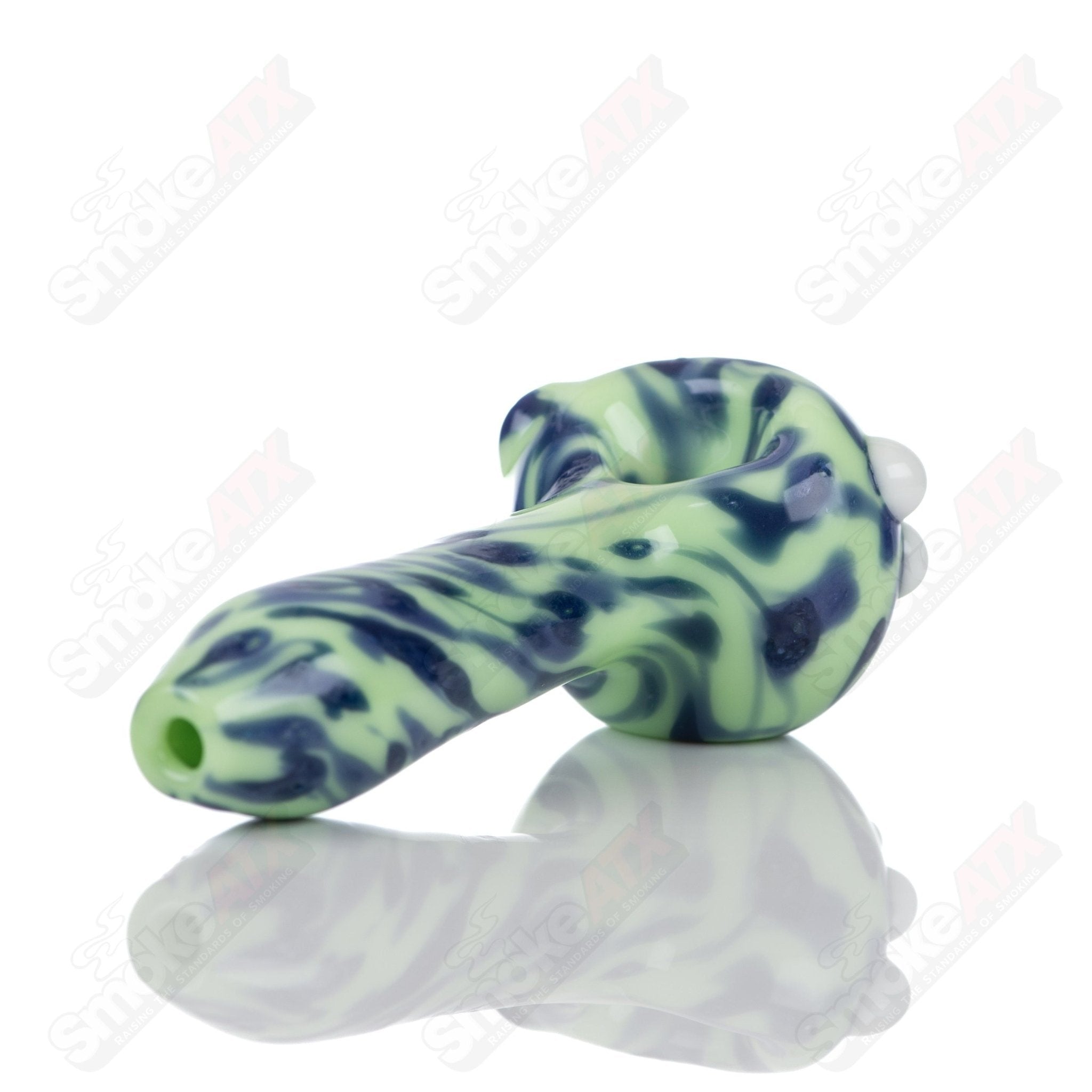 Colorful glass spoon pipe with kiwi splatter design by Adventures In Glass Blowing, showcasing intricate glass blowing craftsmanship.