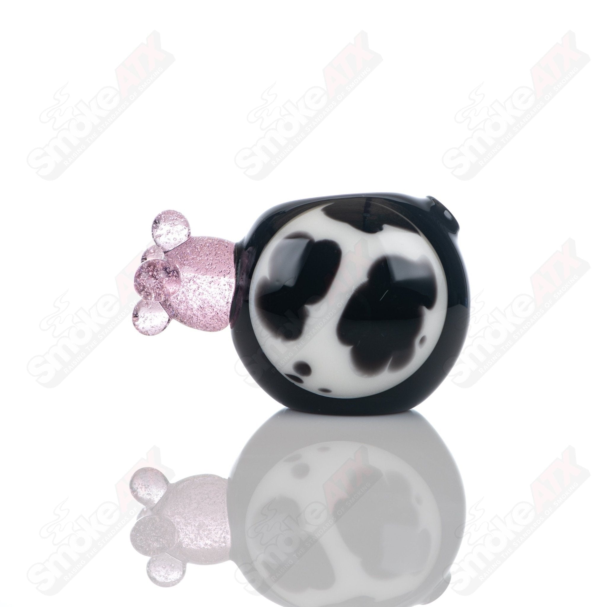 Black cow print glass spoon pipe by Adventures In Glass Blowing, featuring a sleek, curved design with distinctive cow print pattern.