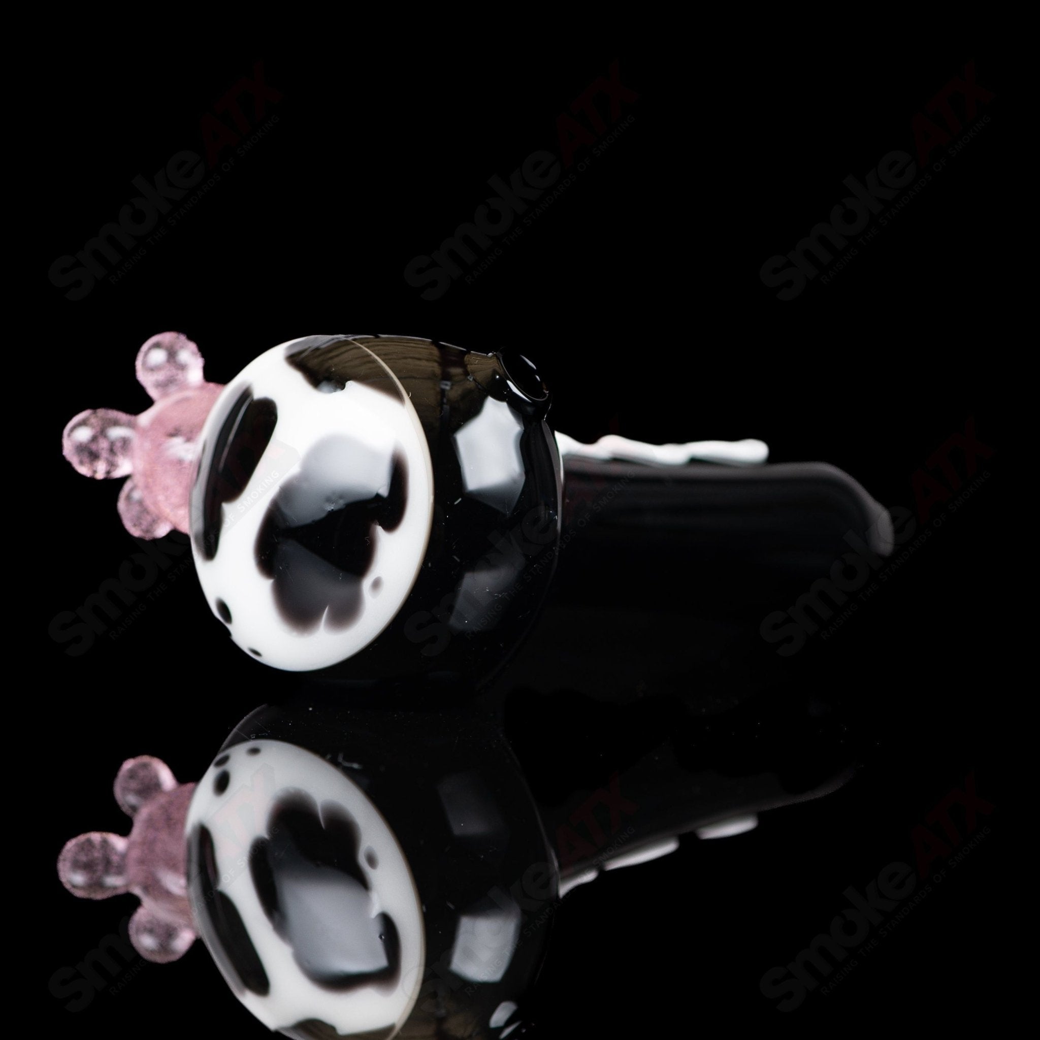 Black cow print glass spoon pipe by Adventures In Glass Blowing, showcasing detailed cow pattern and smooth glass construction.