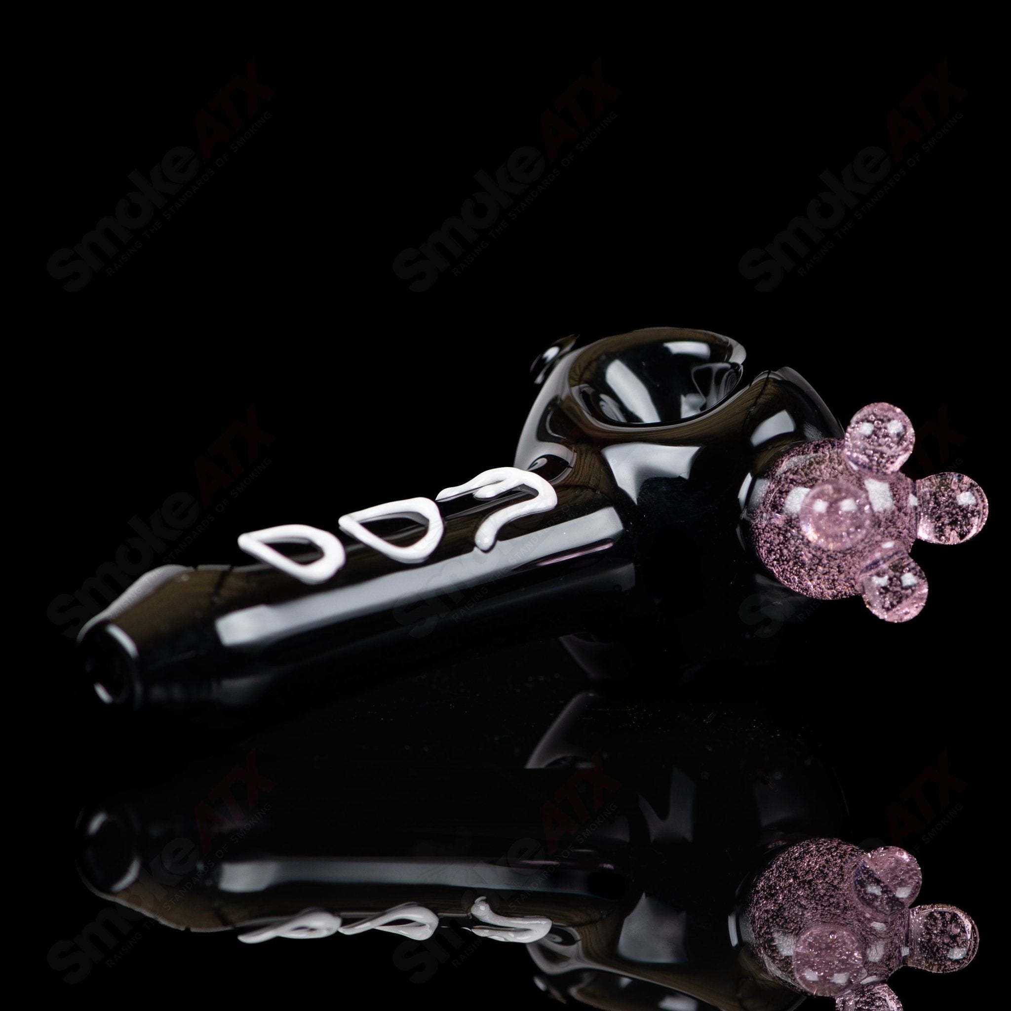 Black cow print glass spoon pipe by Adventures In Glass Blowing, featuring a detailed cow pattern and smooth bowl design.