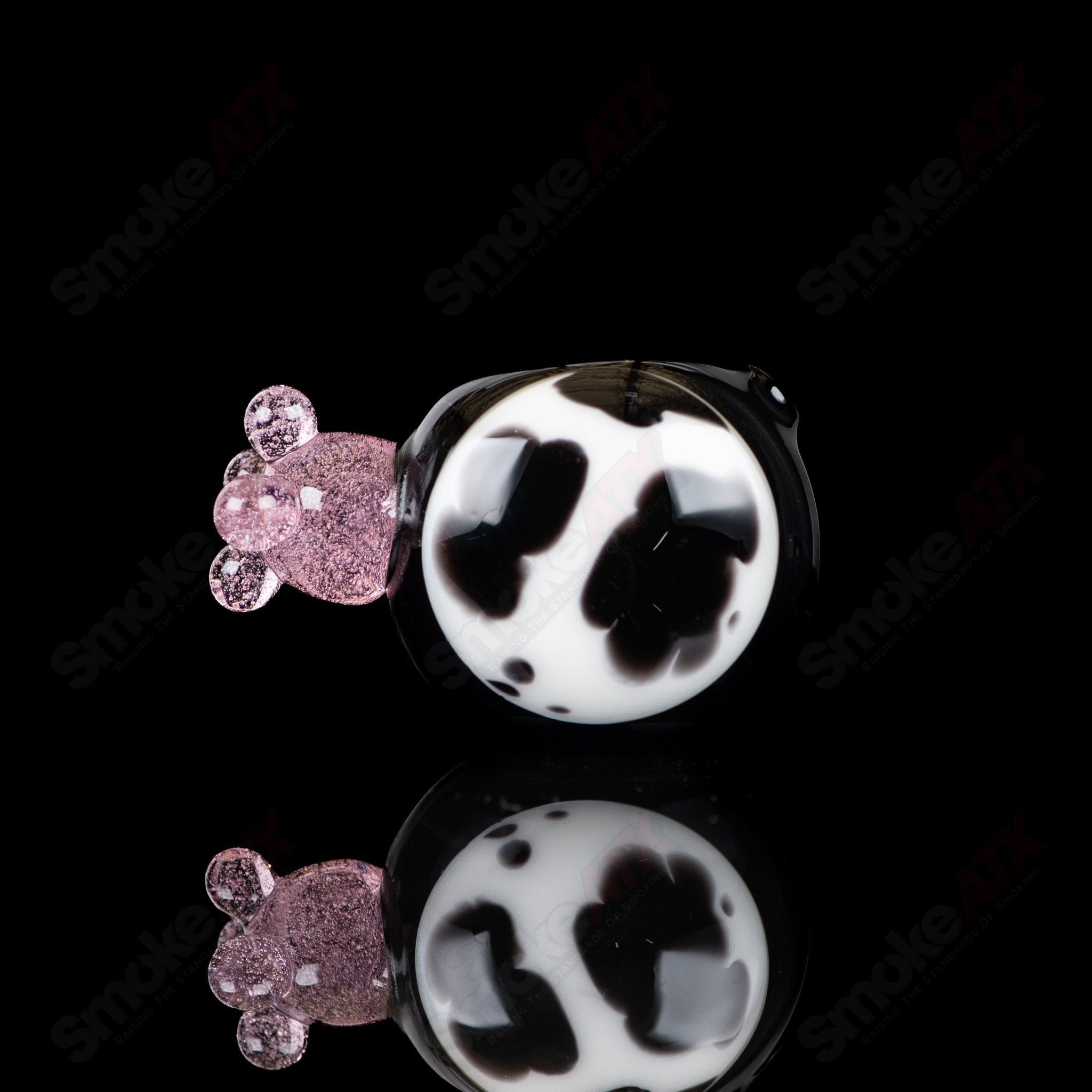 Black cow print glass spoon pipe by Adventures In Glass Blowing, featuring detailed cow pattern and smooth hand-held design.
