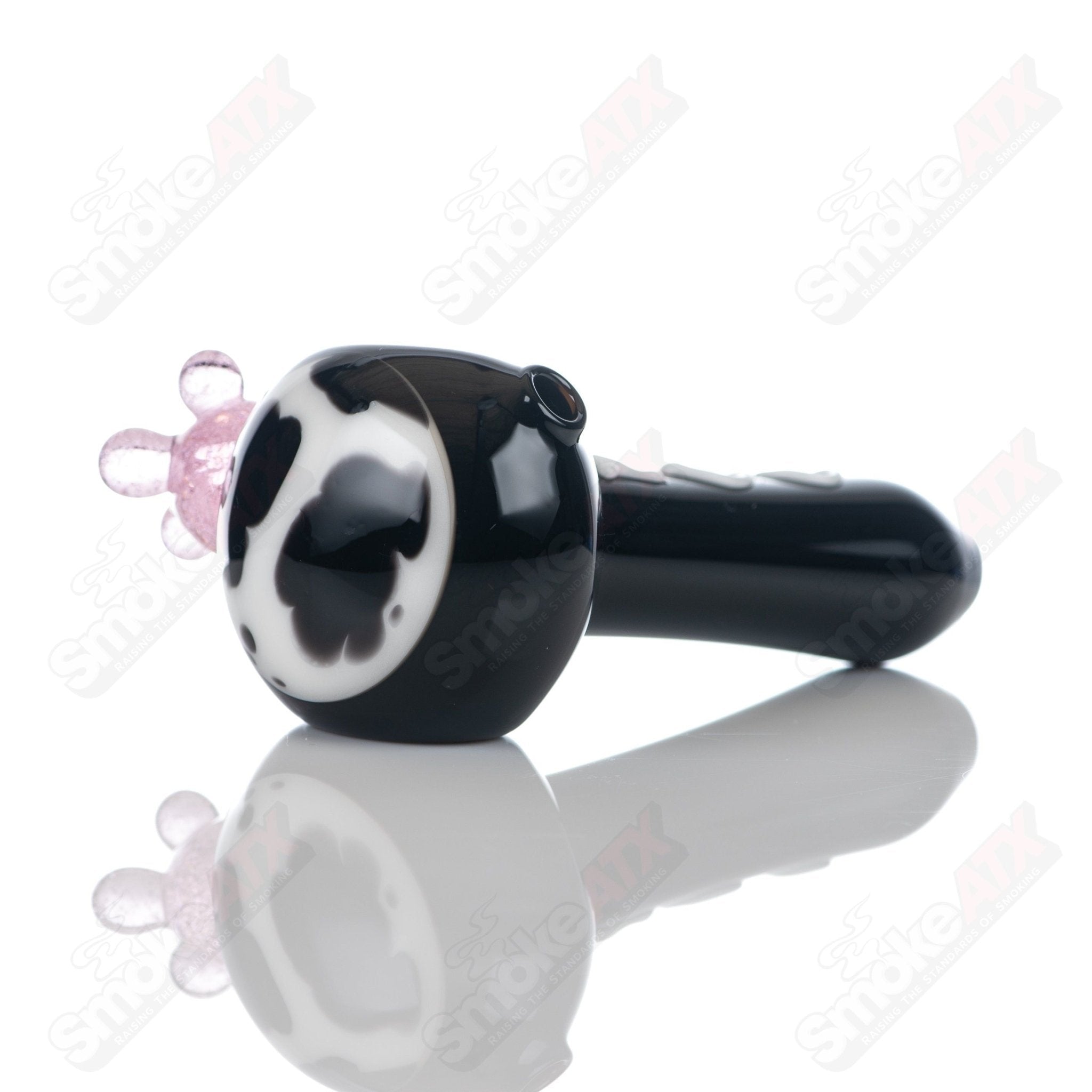 Black cow print glass spoon pipe by Adventures In Glass Blowing, featuring a sleek design with black and white cow print pattern.