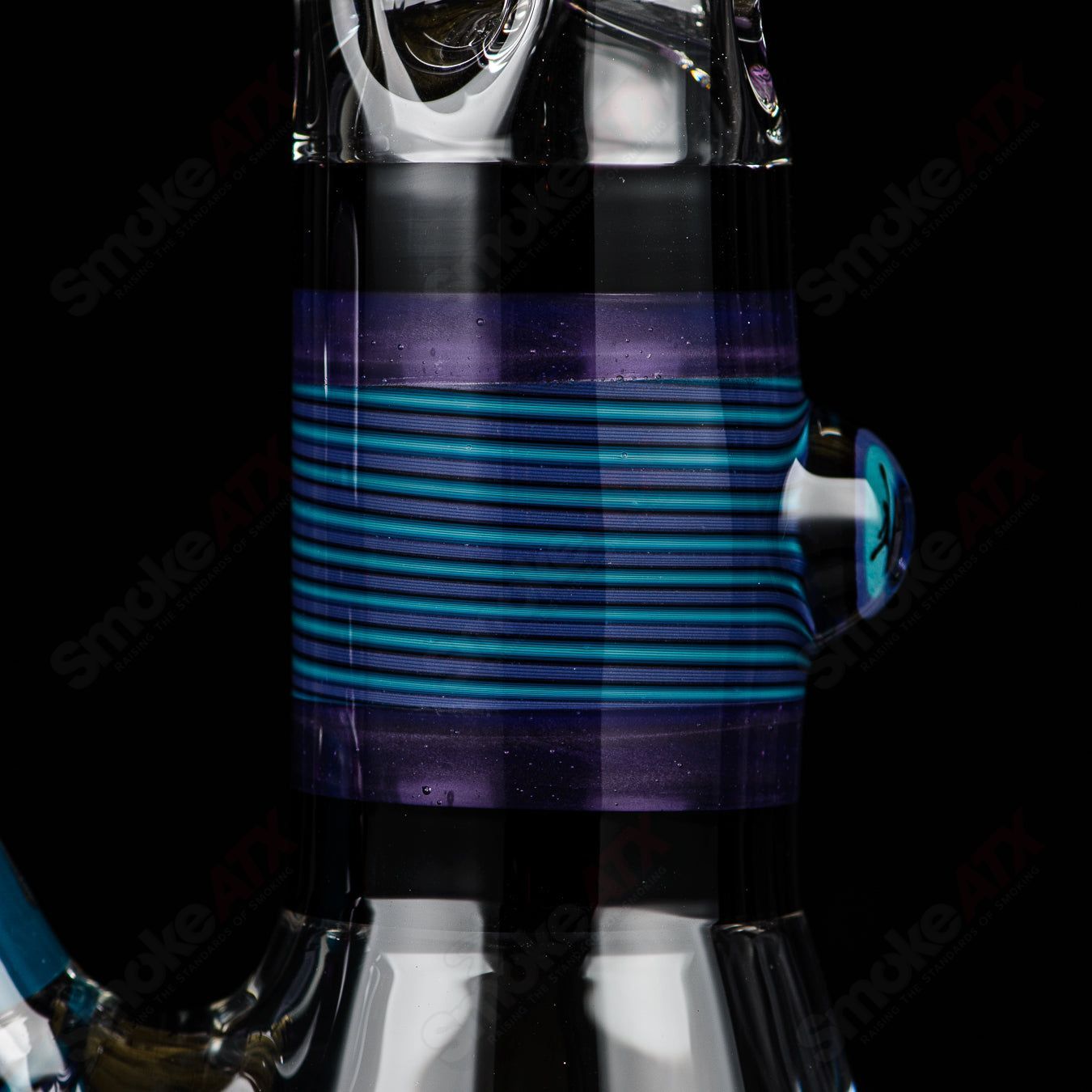 Illadelph purple and aqua Jordan beaker made of heady glass with colorful geometric patterns and a sturdy glass base.