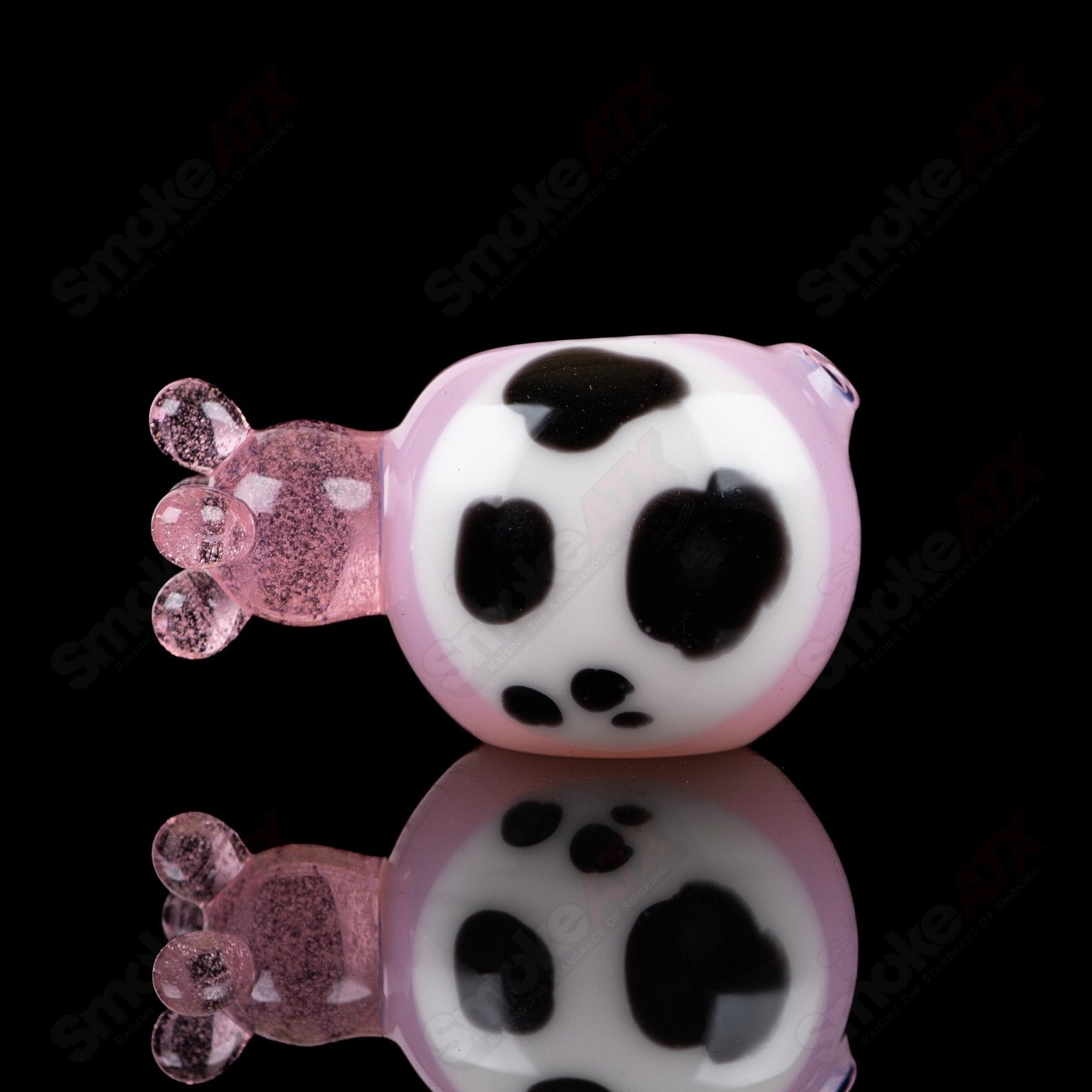 Pink cow print glass spoon pipe by Adventures In Glass Blowing, featuring a detailed, colorful cow pattern on a smooth pipe.