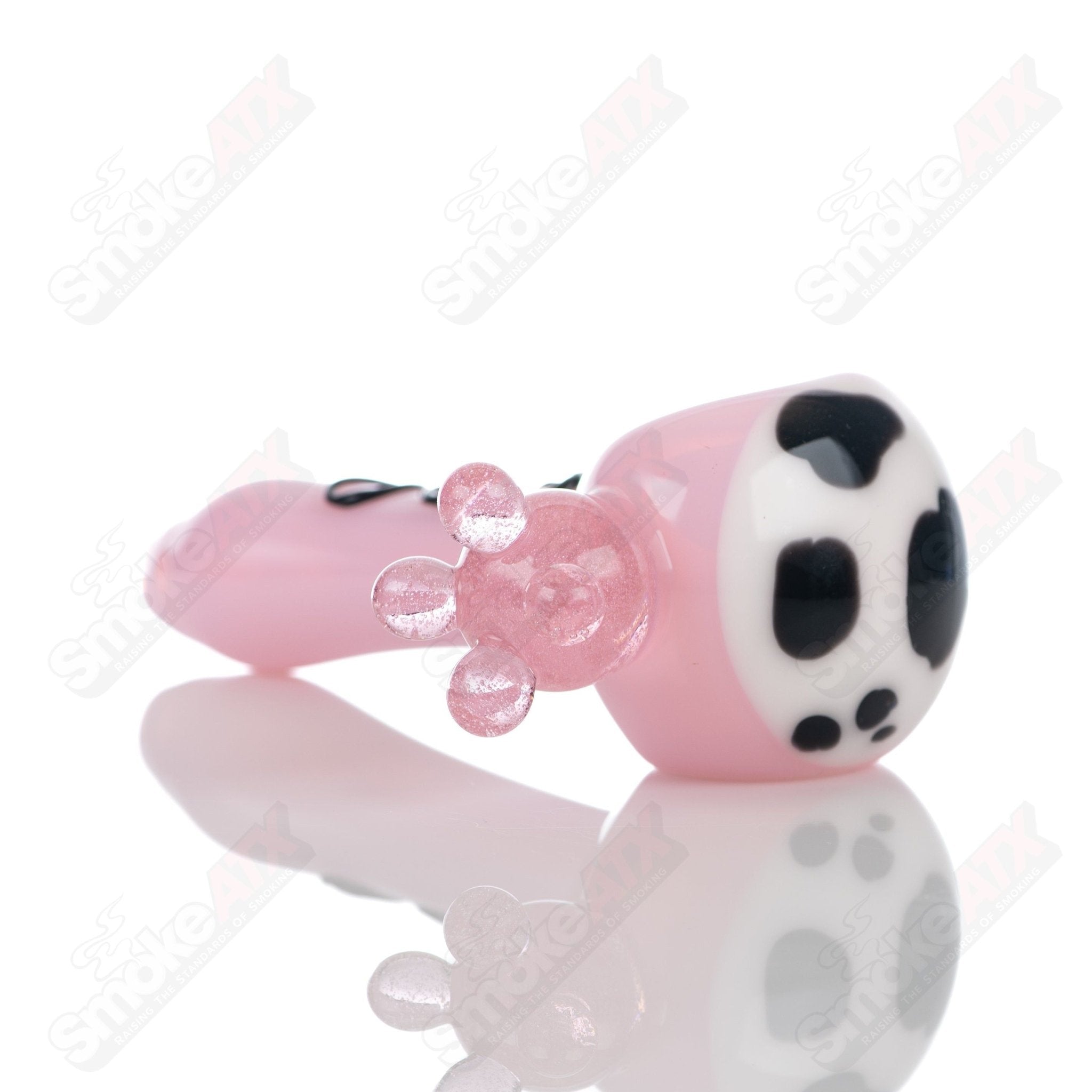 Pink cow print glass spoon pipe by Adventures In Glass Blowing, showcasing colorful, detailed cow pattern on a smooth glass pipe.
