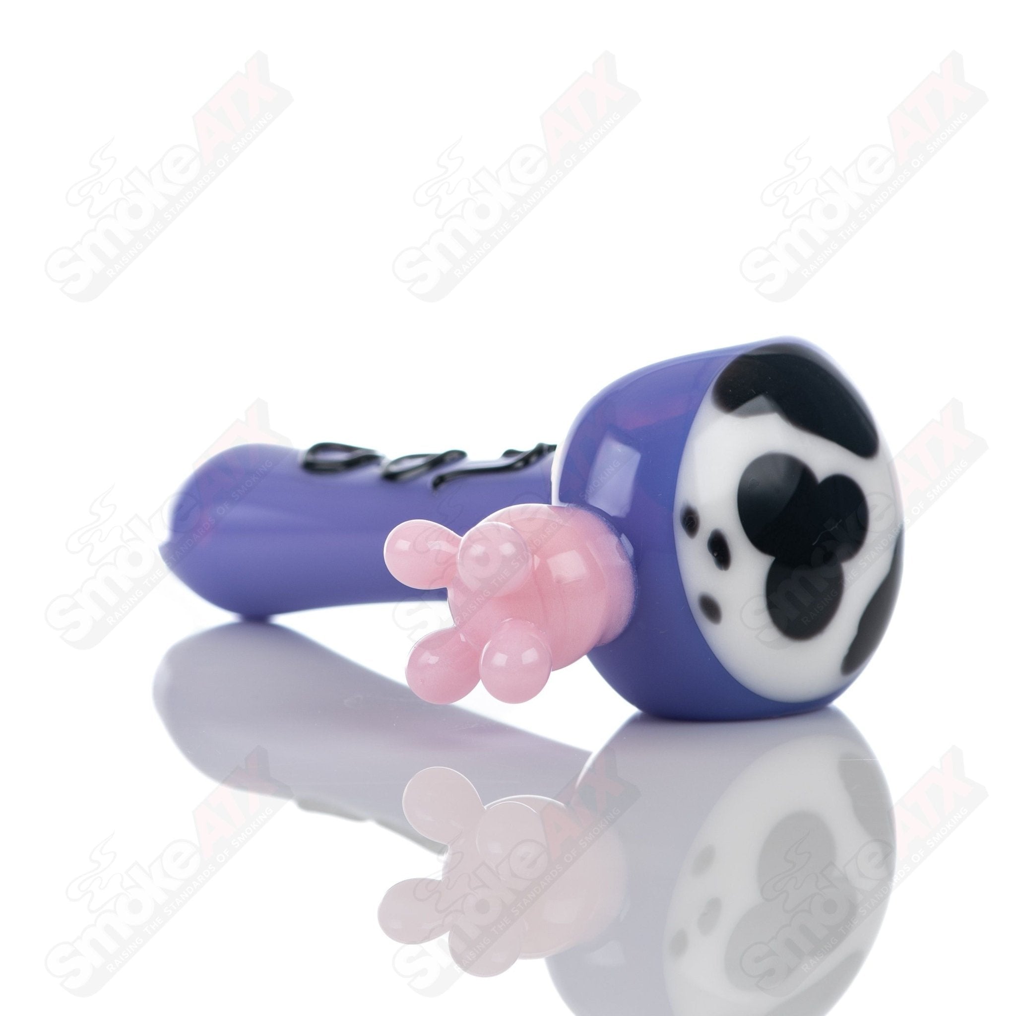 Purple cow print spoon pipe made of glass by Adventures In Glass Blowing, featuring detailed cow pattern and smooth bowl design.