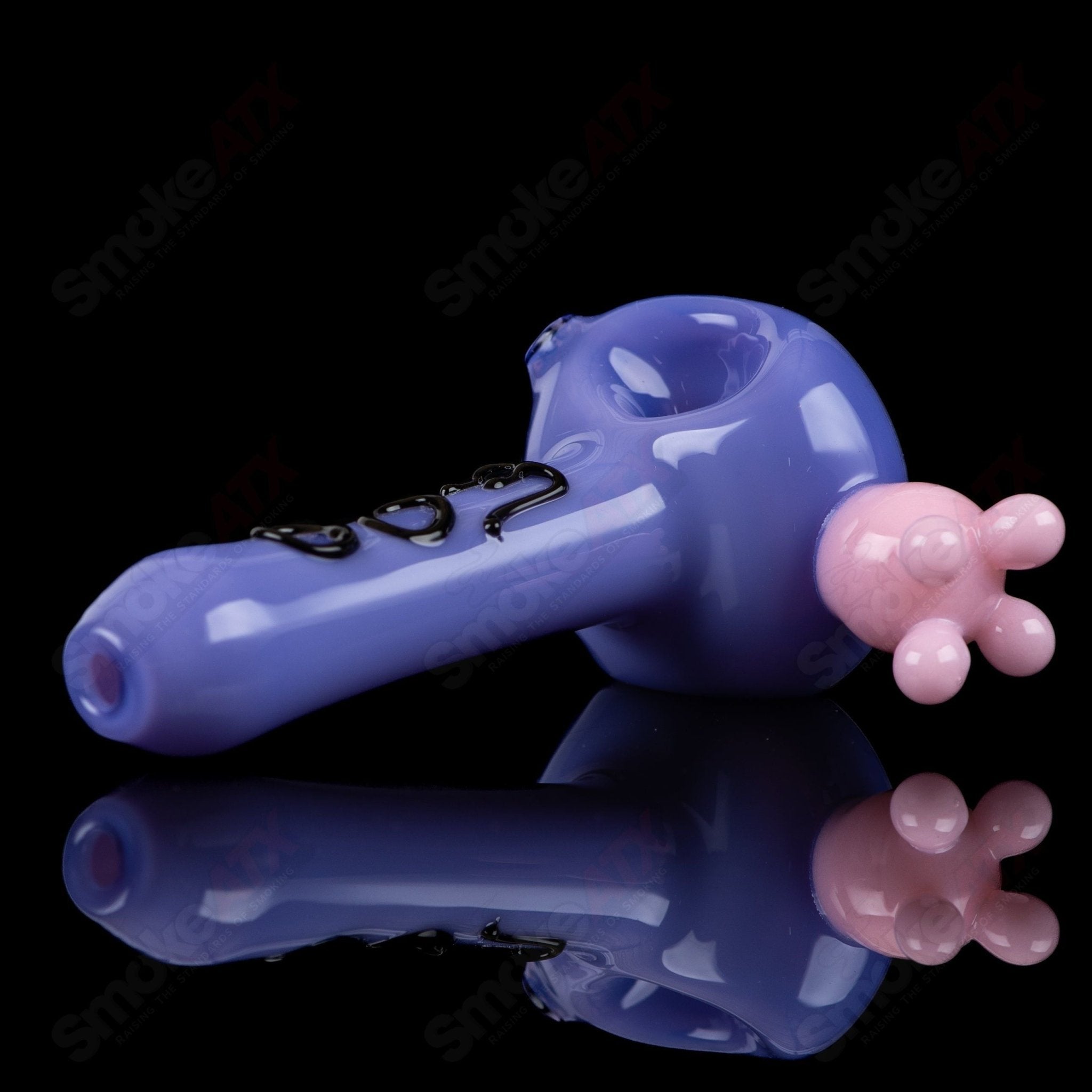 Purple cow print glass spoon pipe by Adventures In Glass Blowing, featuring a colorful cow pattern and smooth curved design.