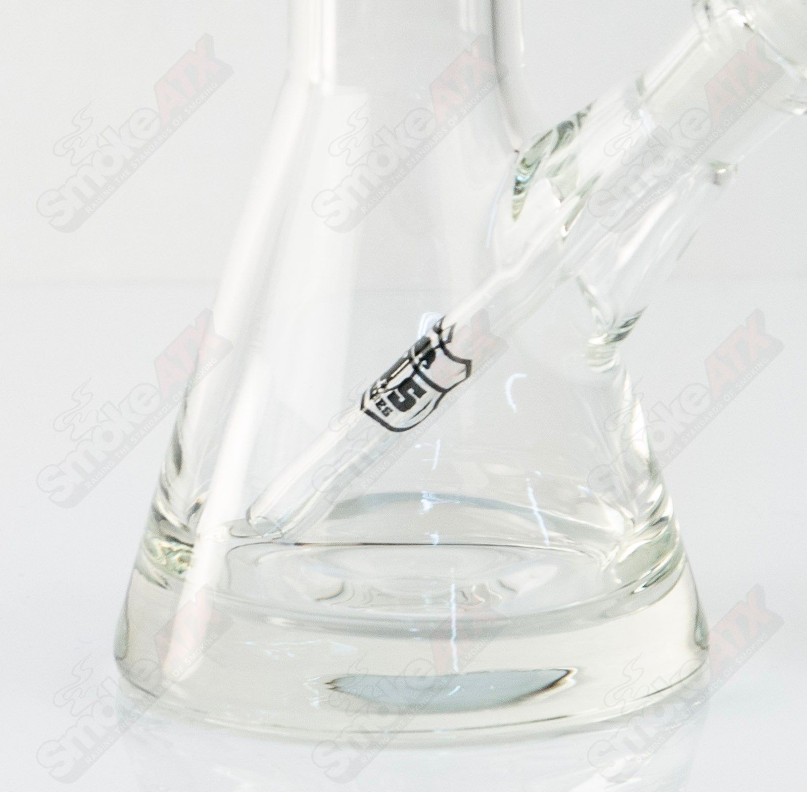 US Tubes 10-inch glass beaker with black shield decal, featuring bold markings and a clear glass design.