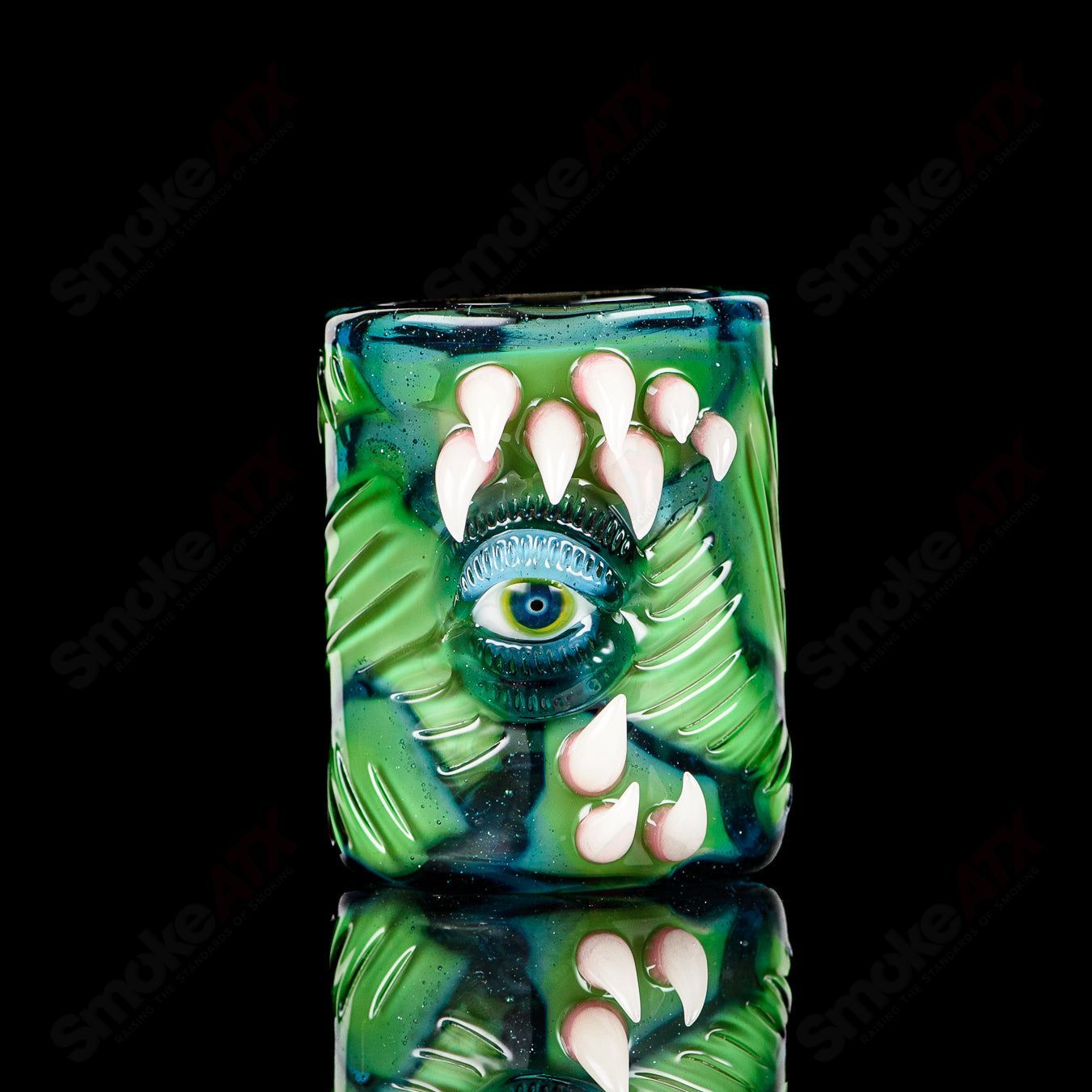UV Salty Eye Shot Glass with teeth design by Salt Glass, a vibrant heady glass cup with a dark, eye-catching appearance.